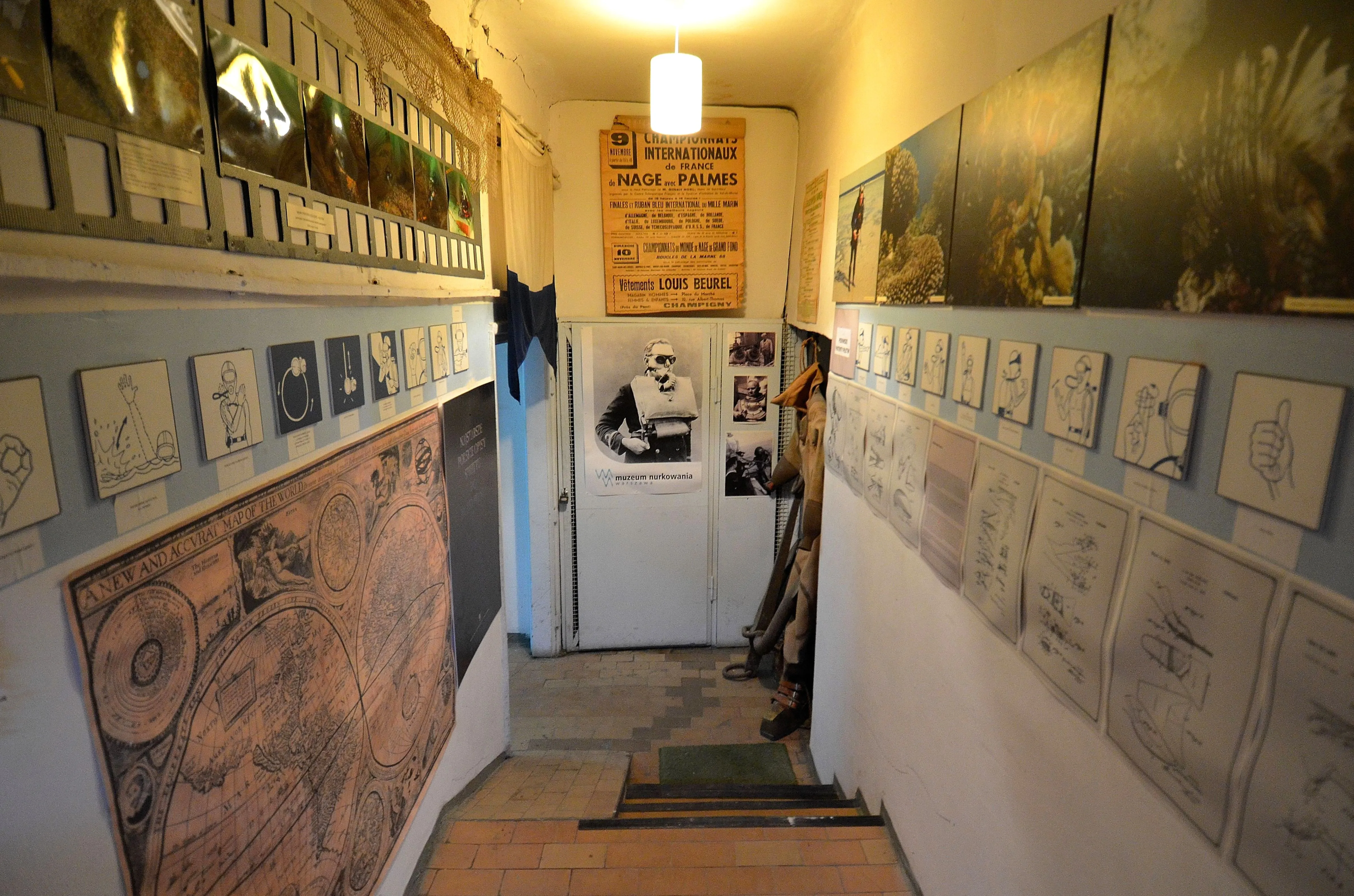 hallway with framed artwork and a diving helmet display