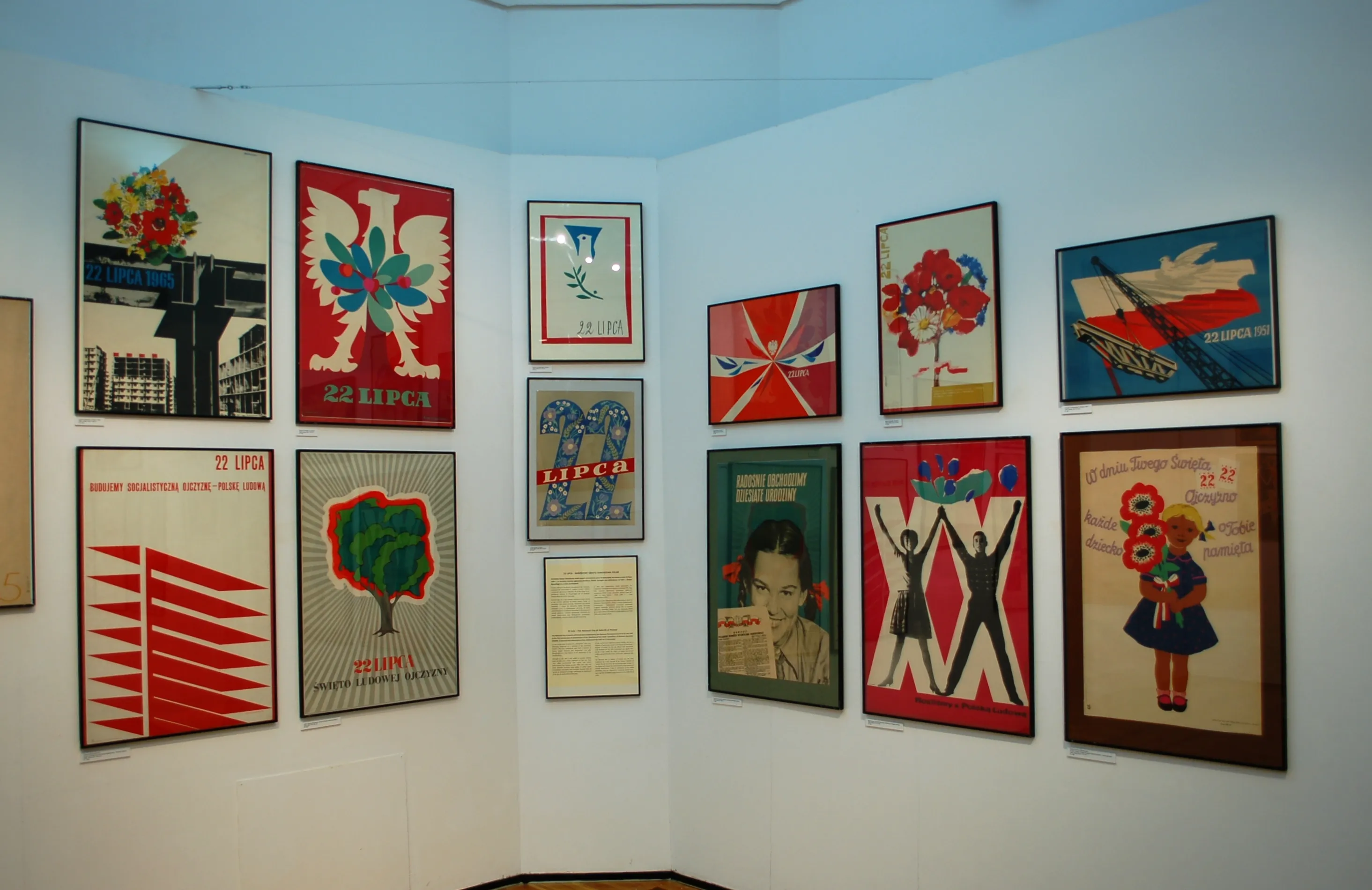 colorful posters on a white wall in a museum gallery