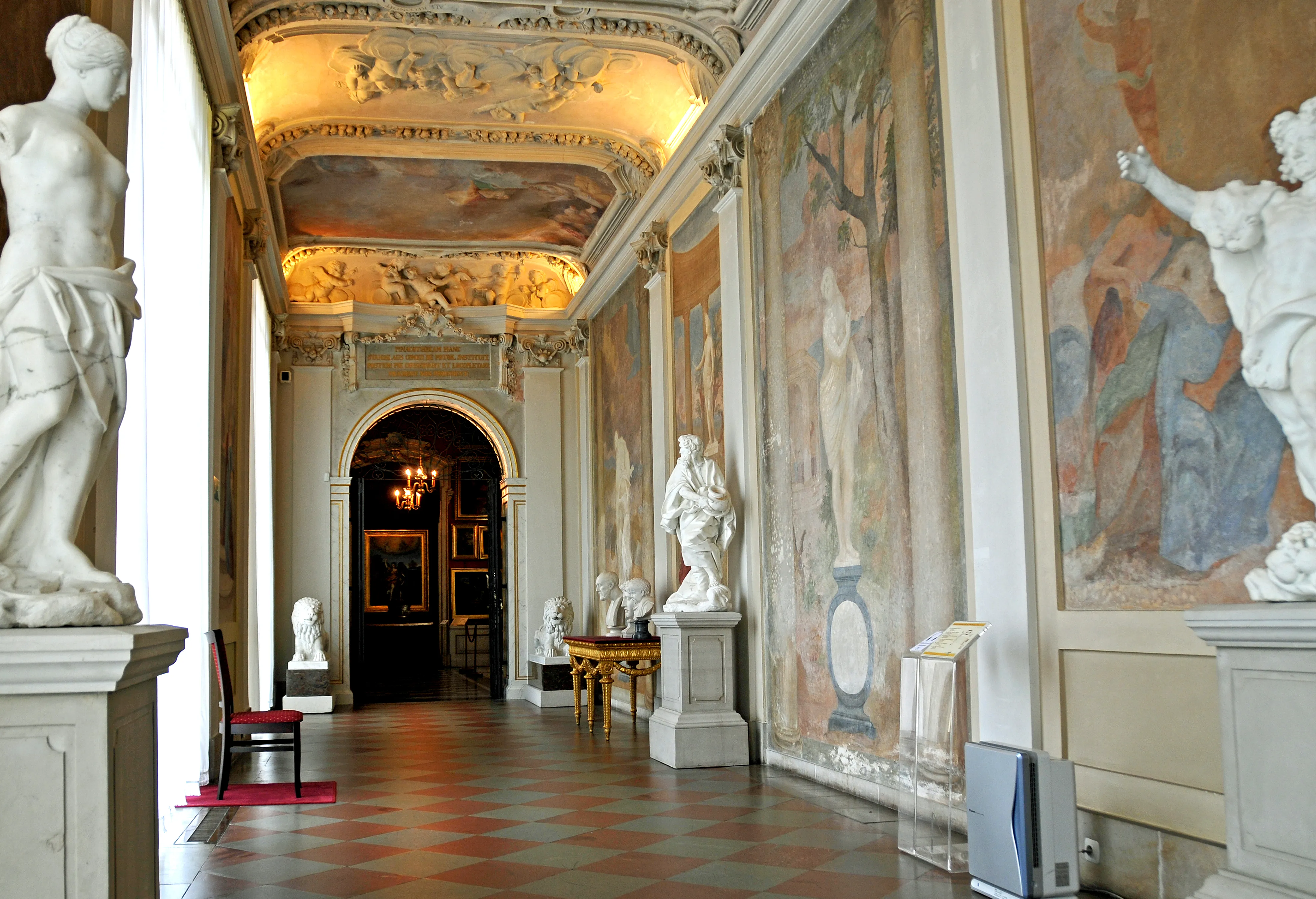 Pasillo barroco con frescos ornamentados en el techo, esculturas clásicas y pinturas murales en el Museo del Palacio del Rey Juan III de Polonia en Wilanów