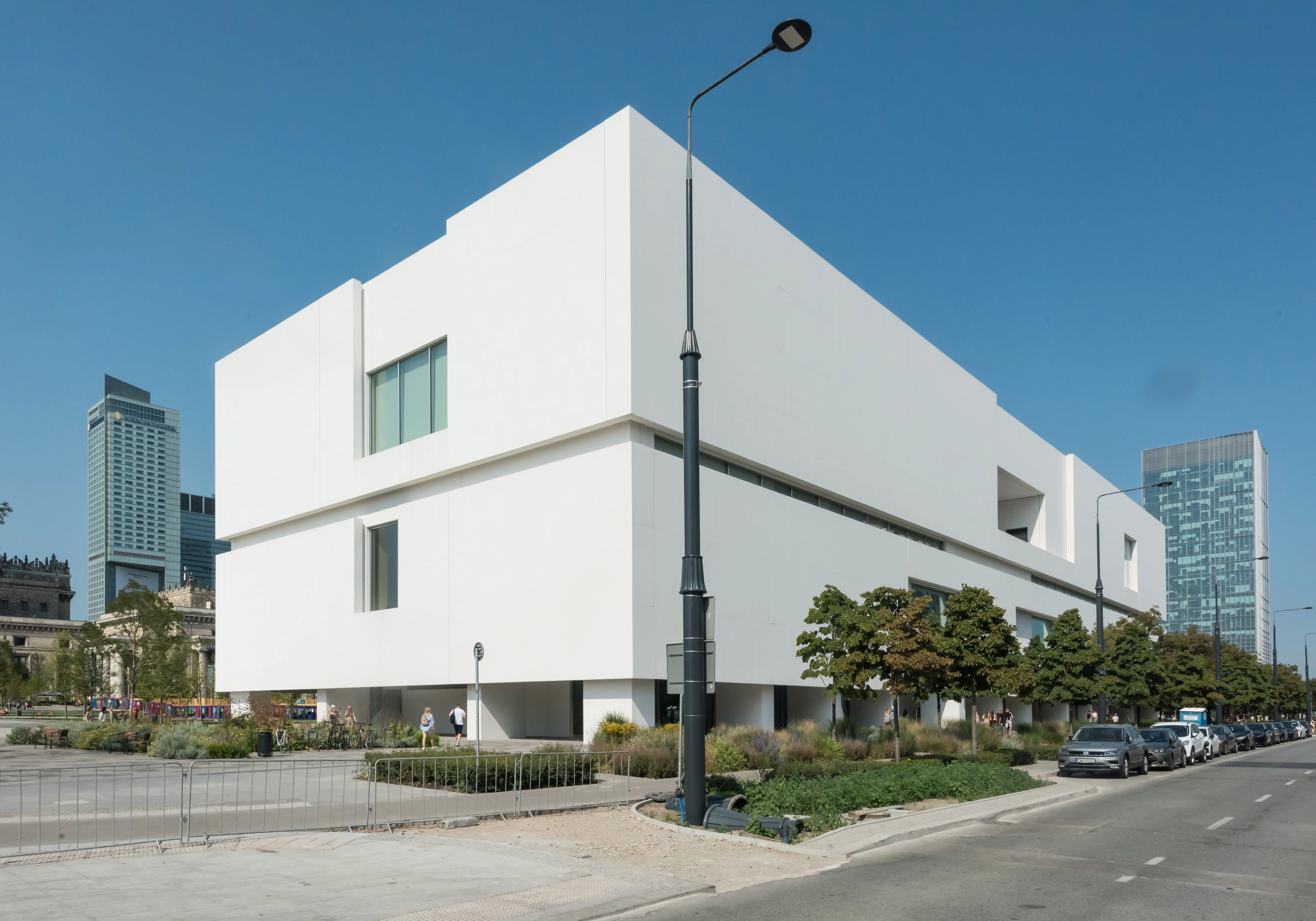 Modern white building with geometric windows and a clear blue sky