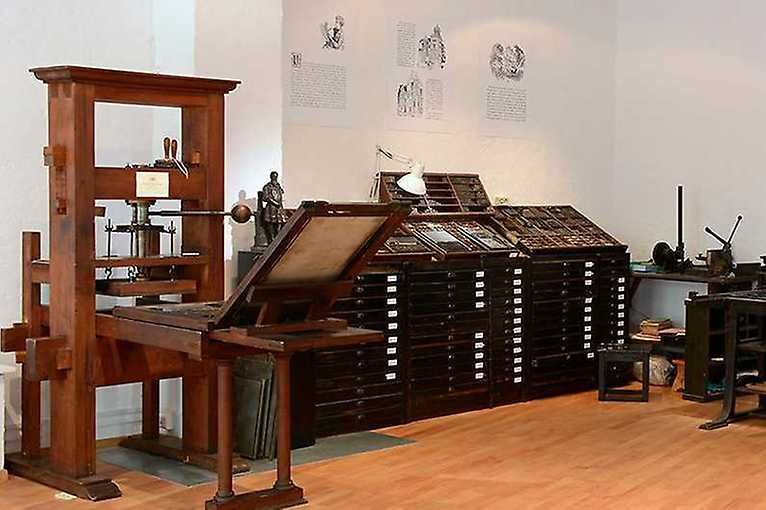 wooden printing press and type drawer cabinet in a museum gallery