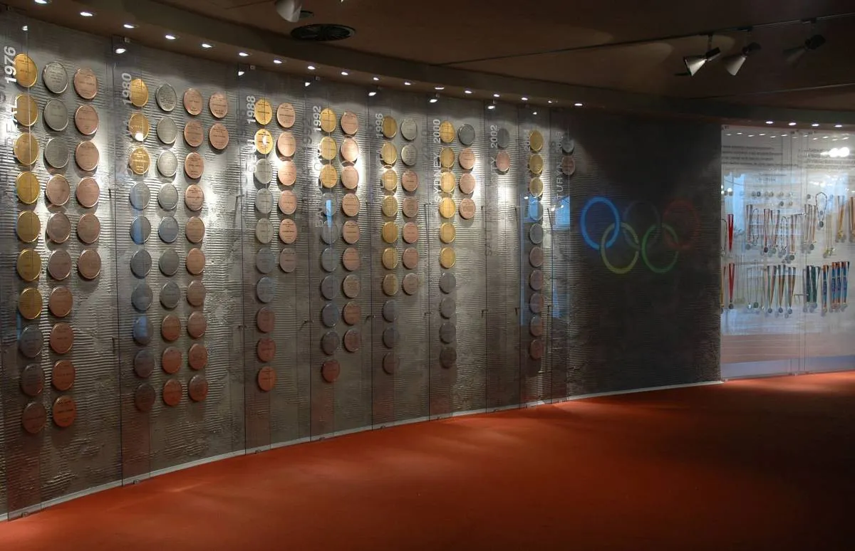 Wall display of medals and Olympic rings inside a museum gallery