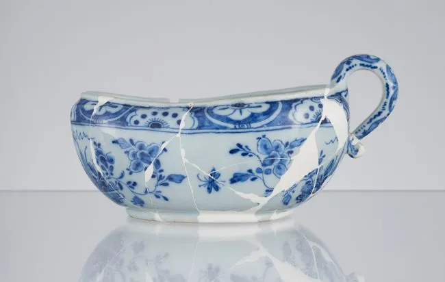 niebiesko-biała ceramiczna misa z motywem kwiatowym i widocznymi pęknięciami