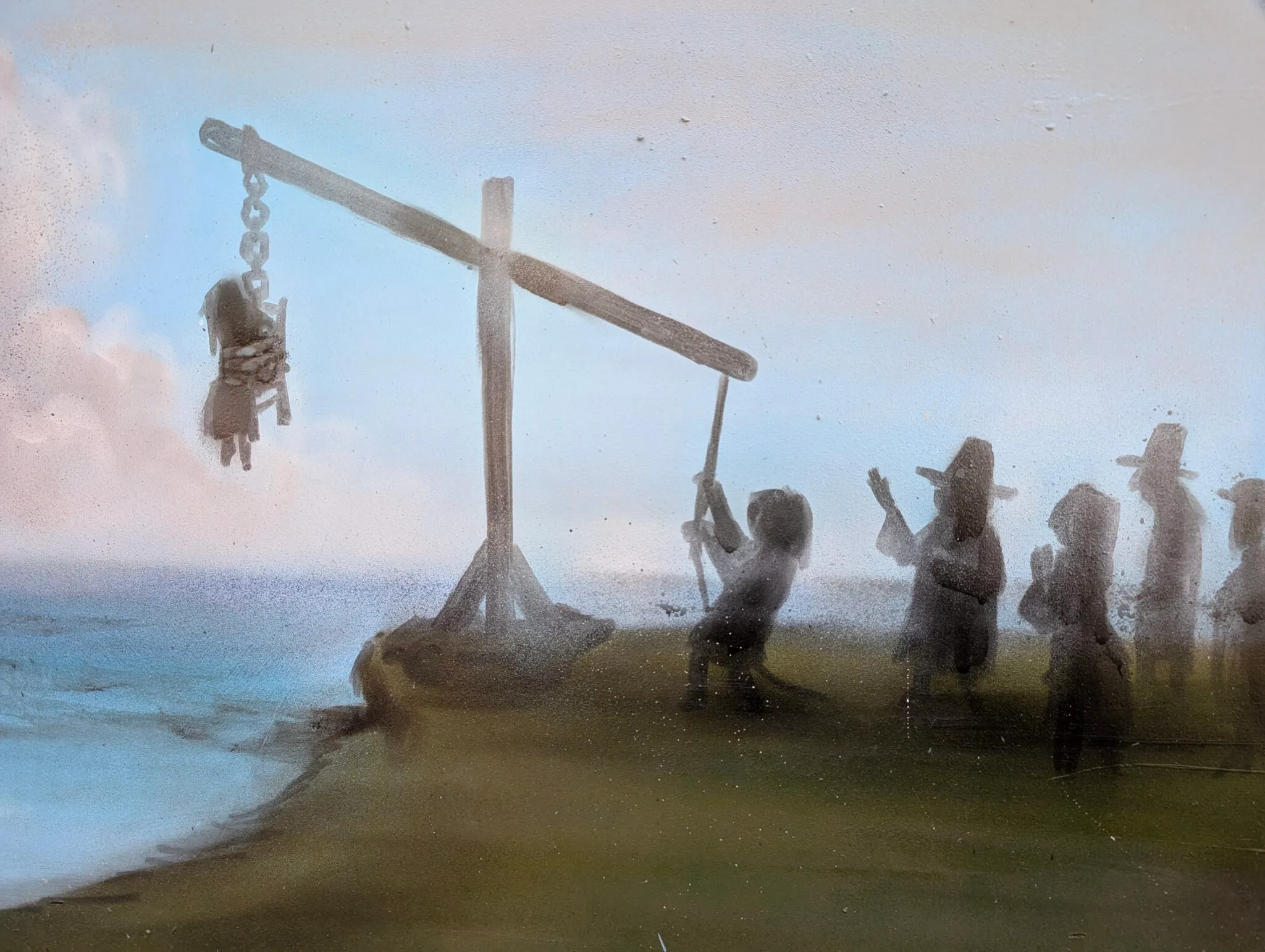 Diorama que representa una escena histórica con figuras cerca de una gran estructura de madera a escala junto al agua, que recrea un juicio o pesaje de brujas.