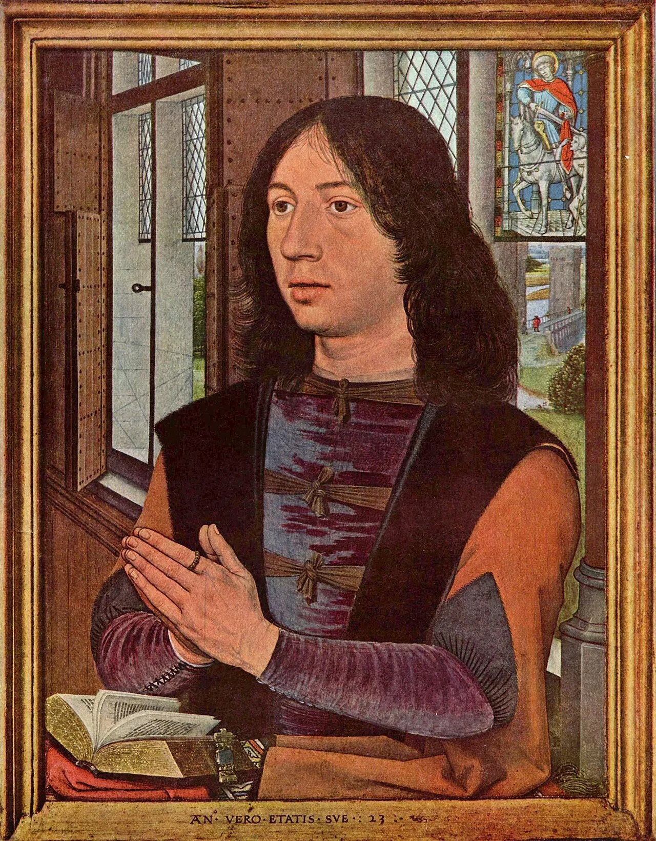 Oil painting portrait of a young man with long dark hair, hands clasped in prayer over an open book, with a stained glass window visible in the background.