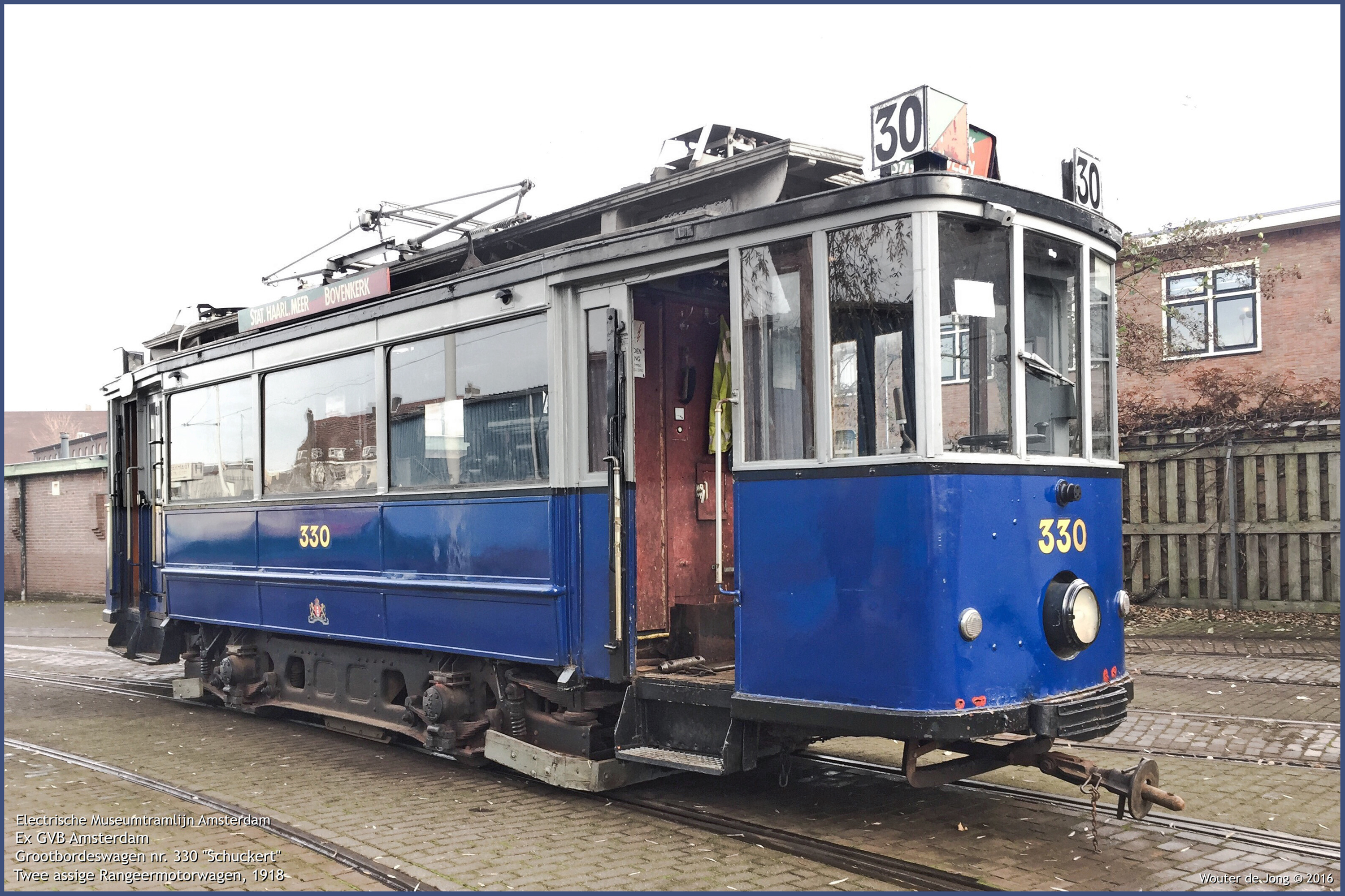 Niebiesko-czarny zabytkowy tramwaj numer 330 na torach z otwartymi drzwiami i przewodami napowietrznymi