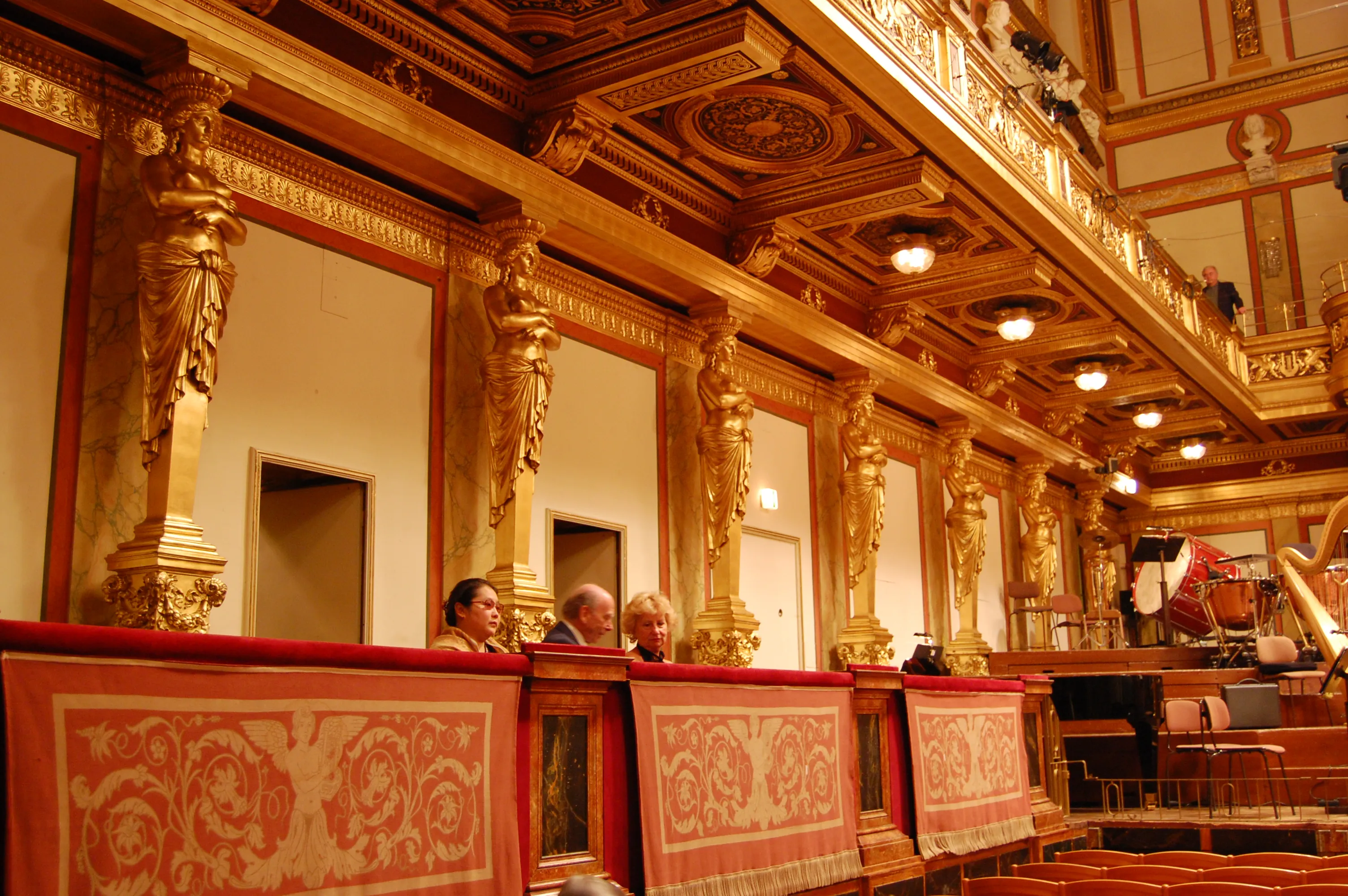 Gouden zuilen en sierlijk plafond in de Gouden Zaal van de Musikverein met rood patroonbehang