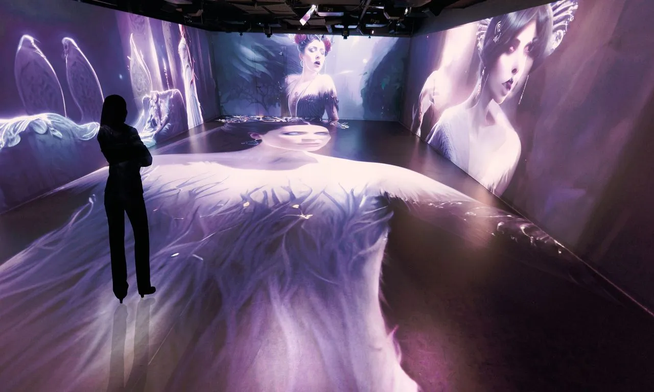 Silhouette of a person standing in a dark room with large projections of figures and white fabric on the walls and floor