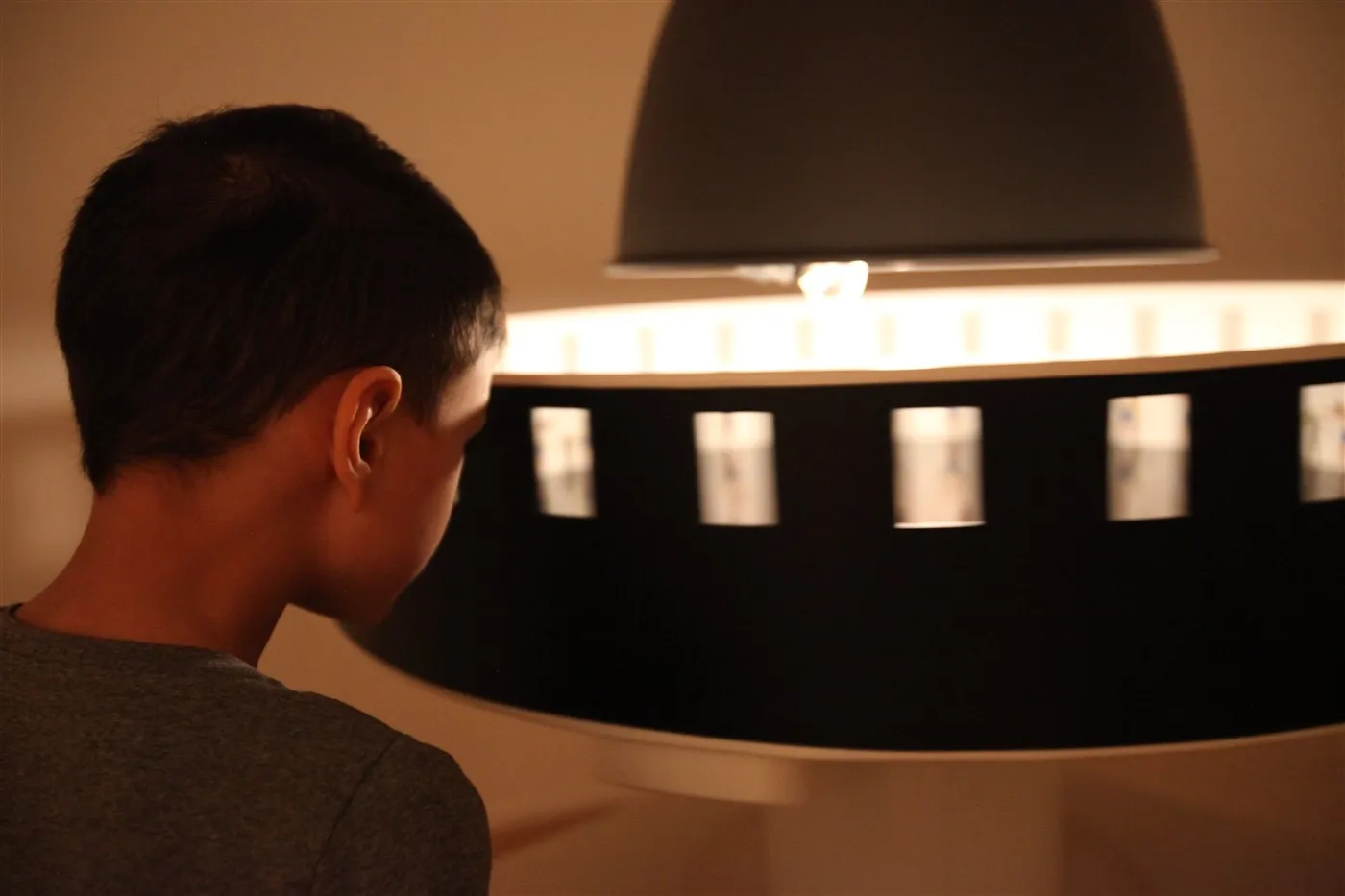 a child looking at a circular display with illuminated film strip windows
