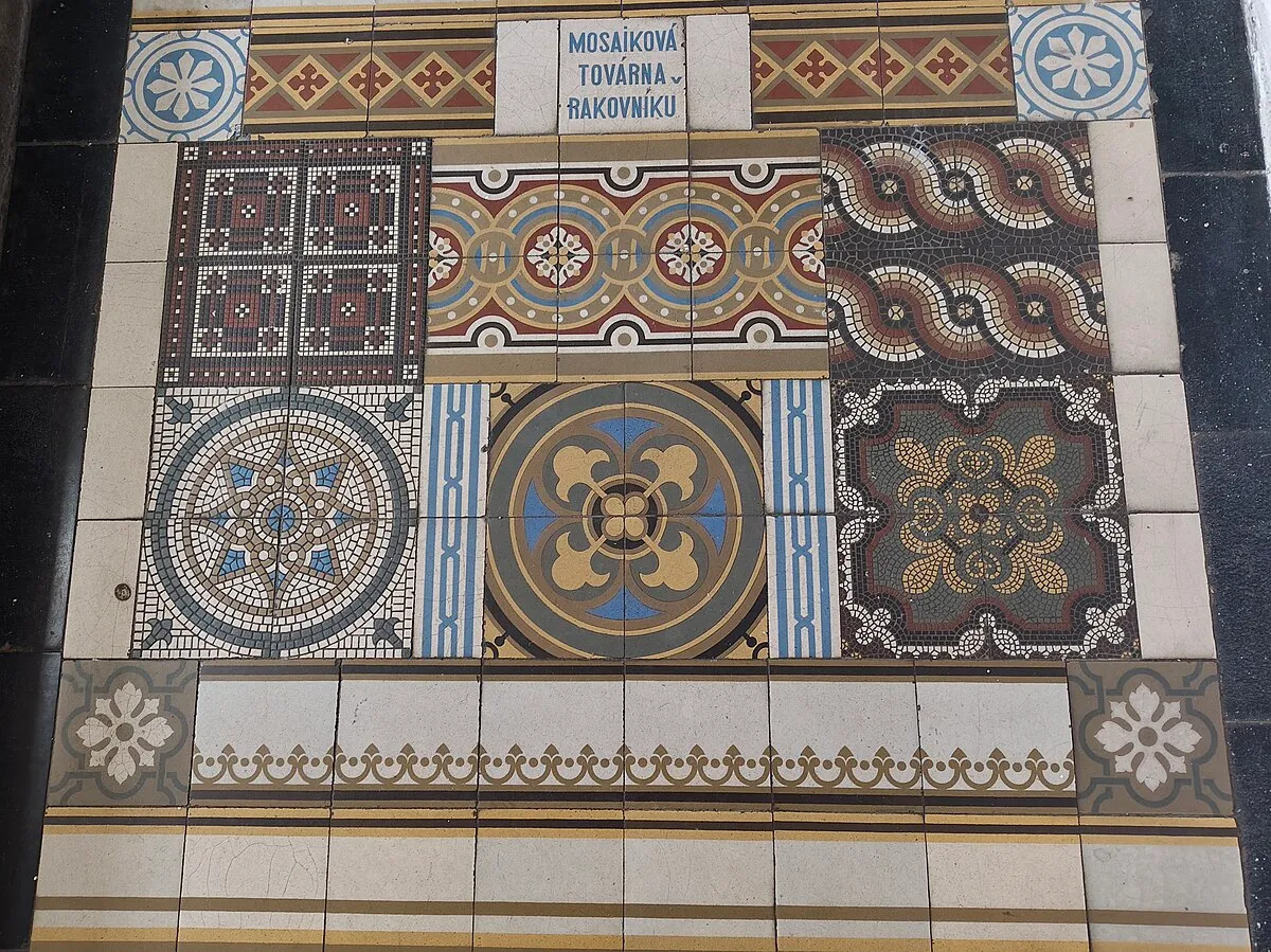 pared decorativa de azulejos con intrincados patrones y un cartel que dice MUSEUMOVÁ TOVÁRNA - NÁKOVÍKO