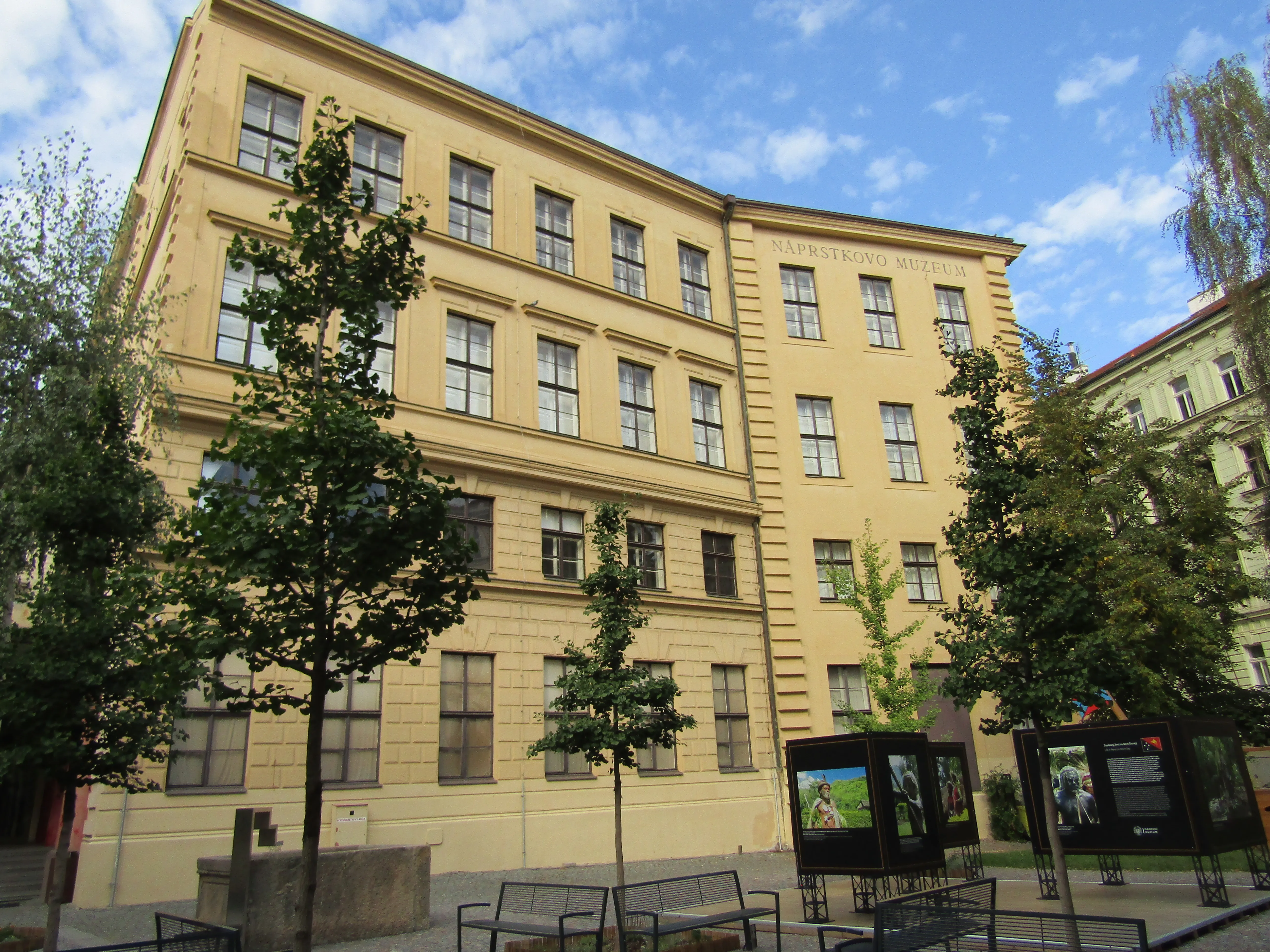 żółty budynek z wieloma oknami i drzewami z przodu