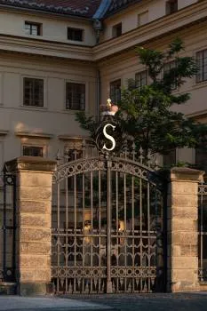 Ozdobna kuta brama z monogramem 'S' przy wejściu do Pałacu Salmów
