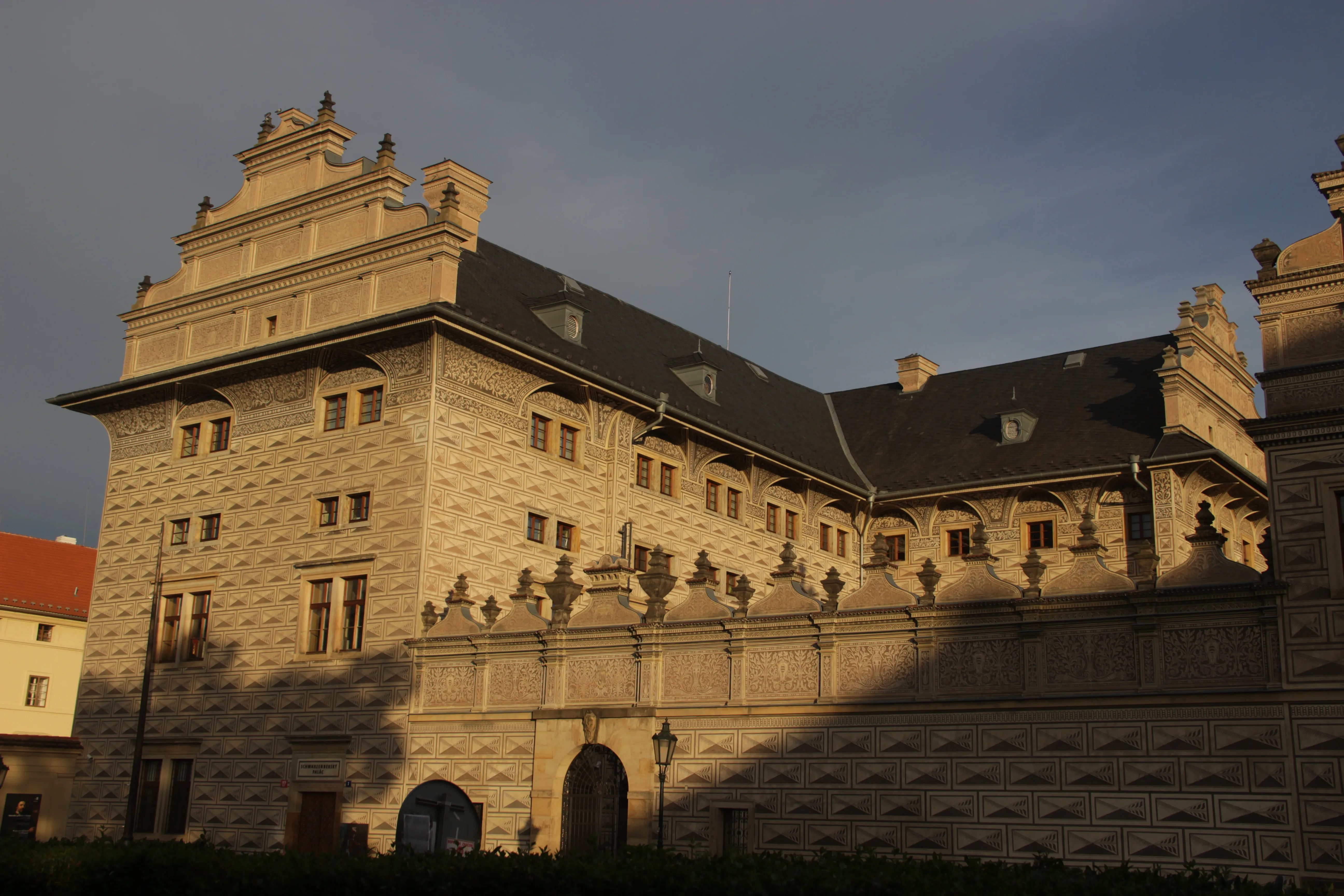 Renesansowy pałac z kamienną fasadą i ozdobną linią dachu o zmierzchu