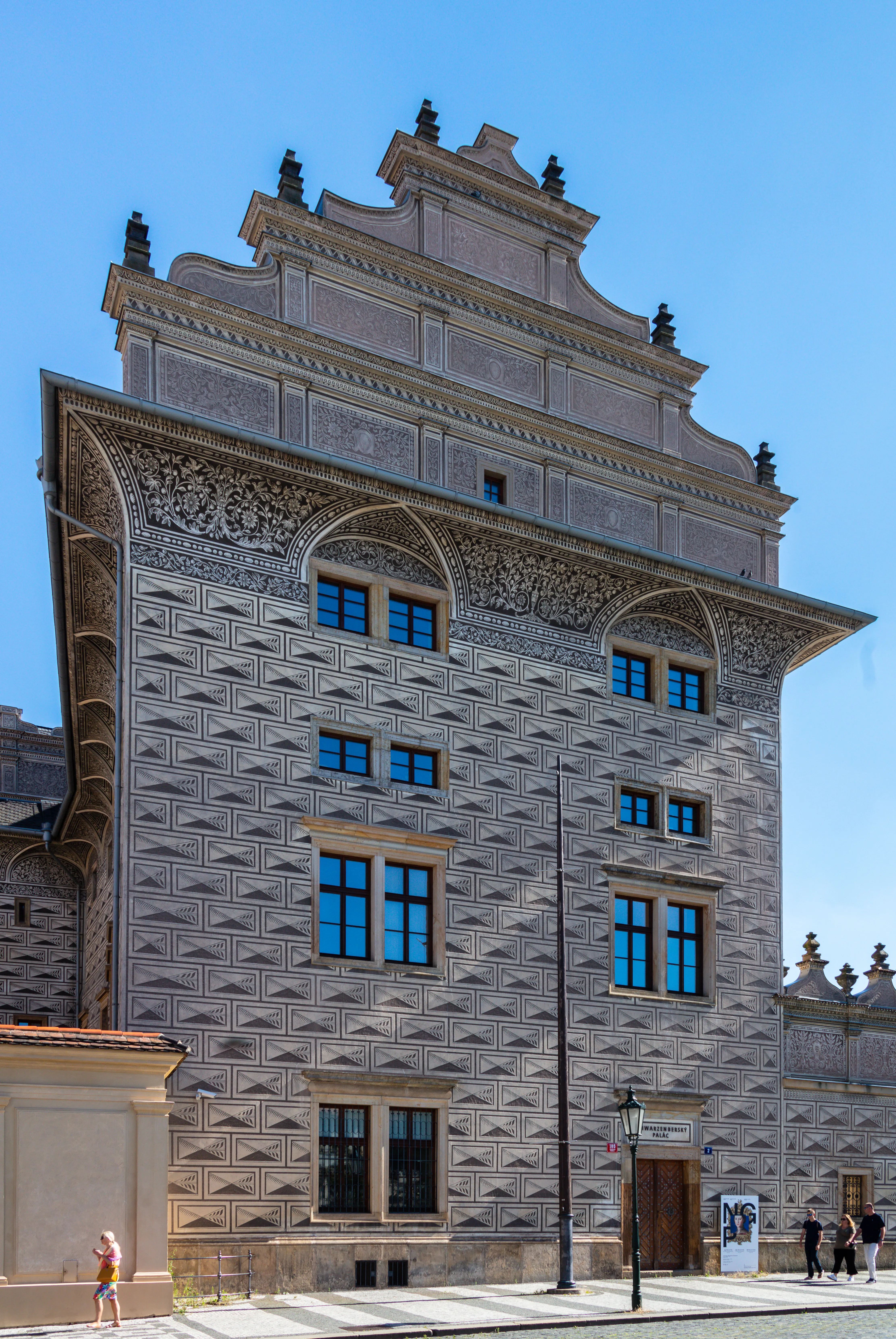 Renesansowy pałac ze misterną kamienną fasadą i niebieskimi oknami pod czystym niebem