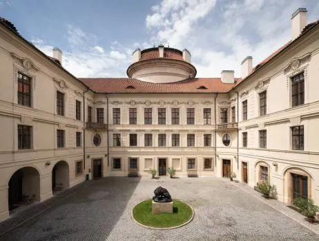 Dziedziniec Pałacu Sternberg z centralną rzeźbą i barokową architekturą