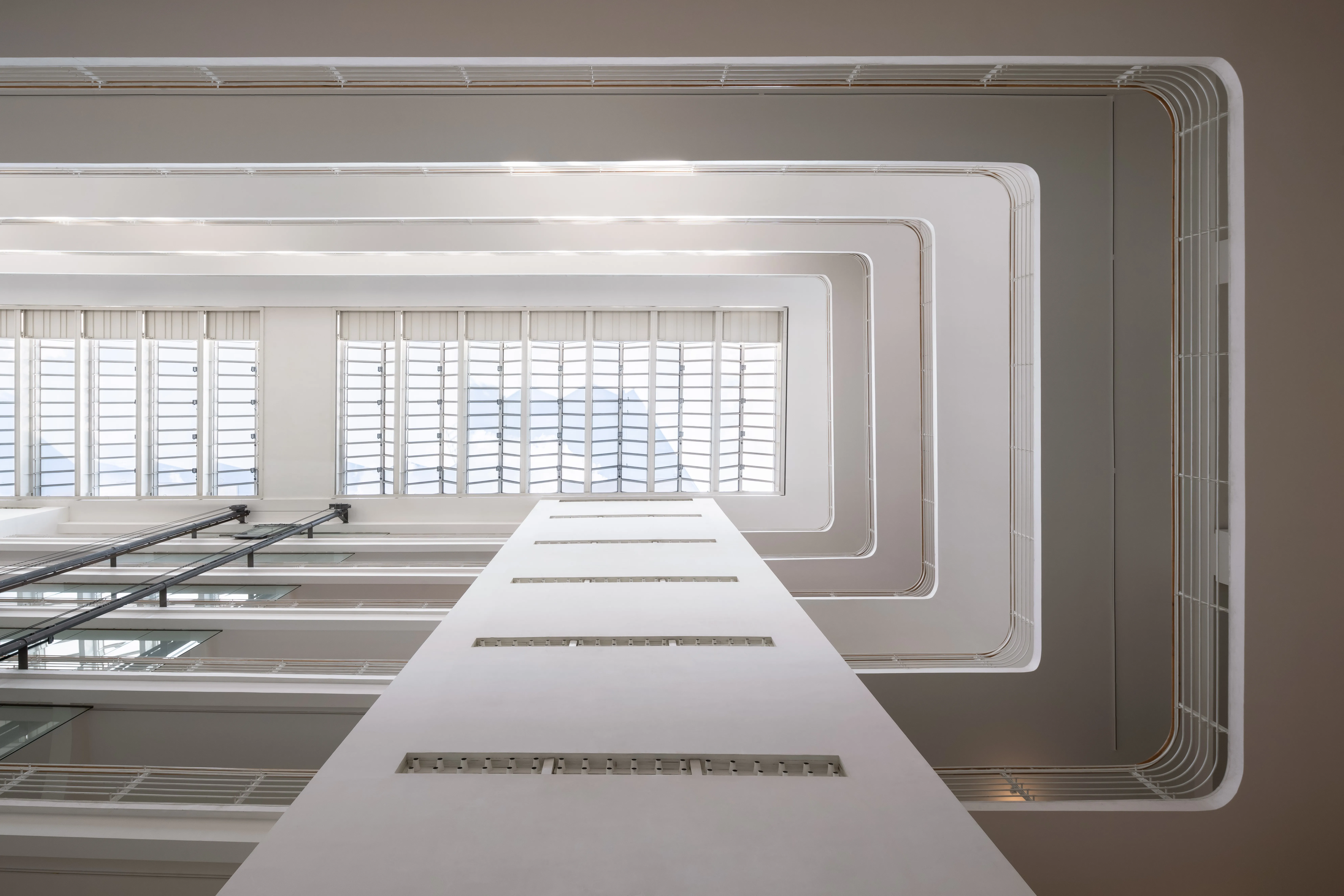 Modern white staircase with geometric architectural design and large windows