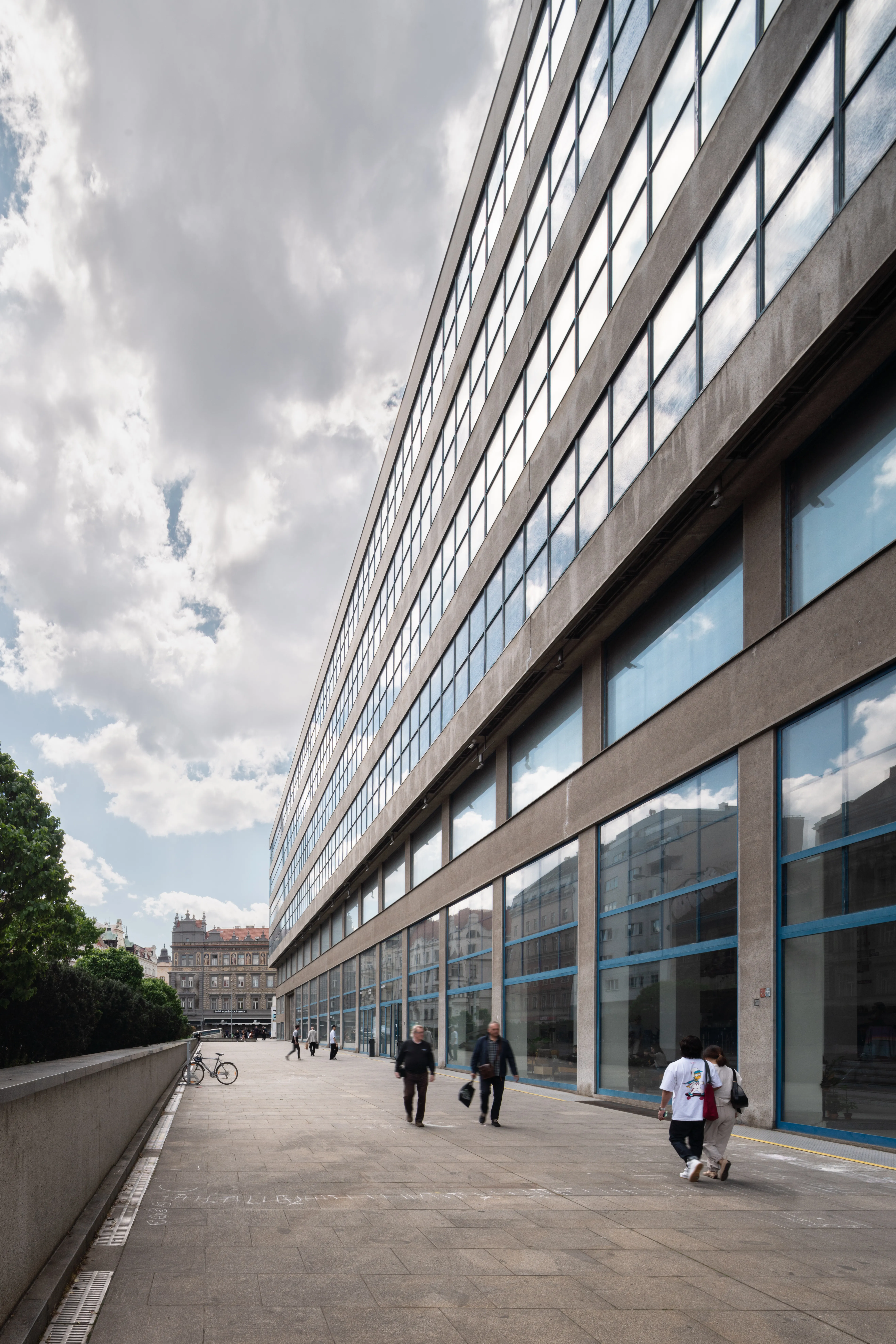 edificio modernista con ventanas de cristal y fachada de hormigón bajo un cielo nublado