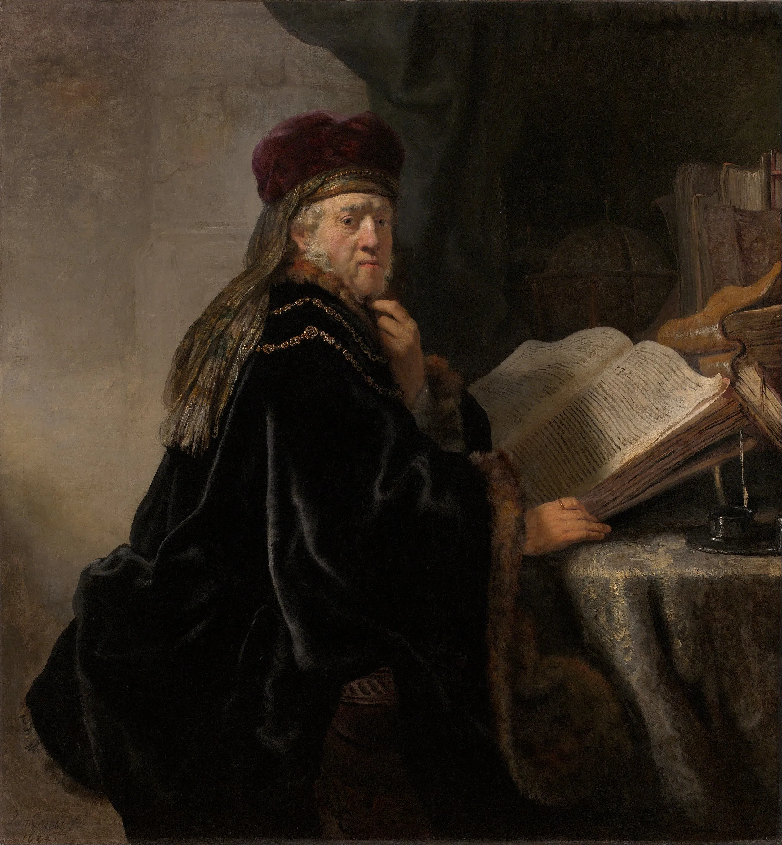 A man in a red hat and dark robe sits at a table with an open book, a candle, and a globe in the background.