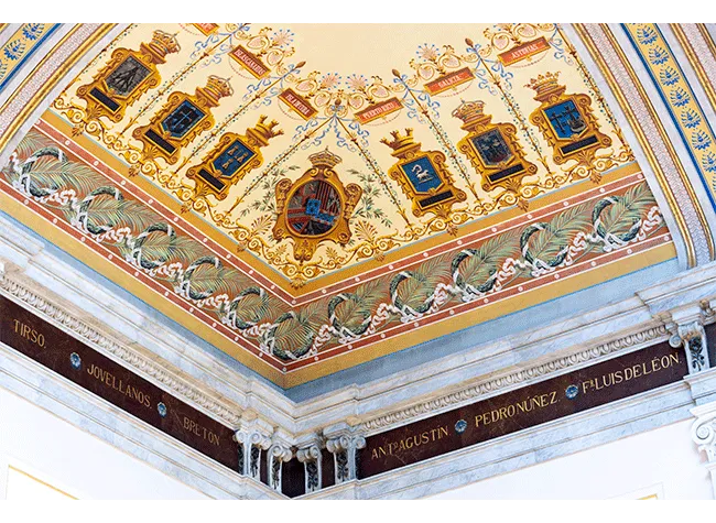 Ozdobny sufit ze złotymi i niebieskimi emblematami i dekoracyjnymi wzorami