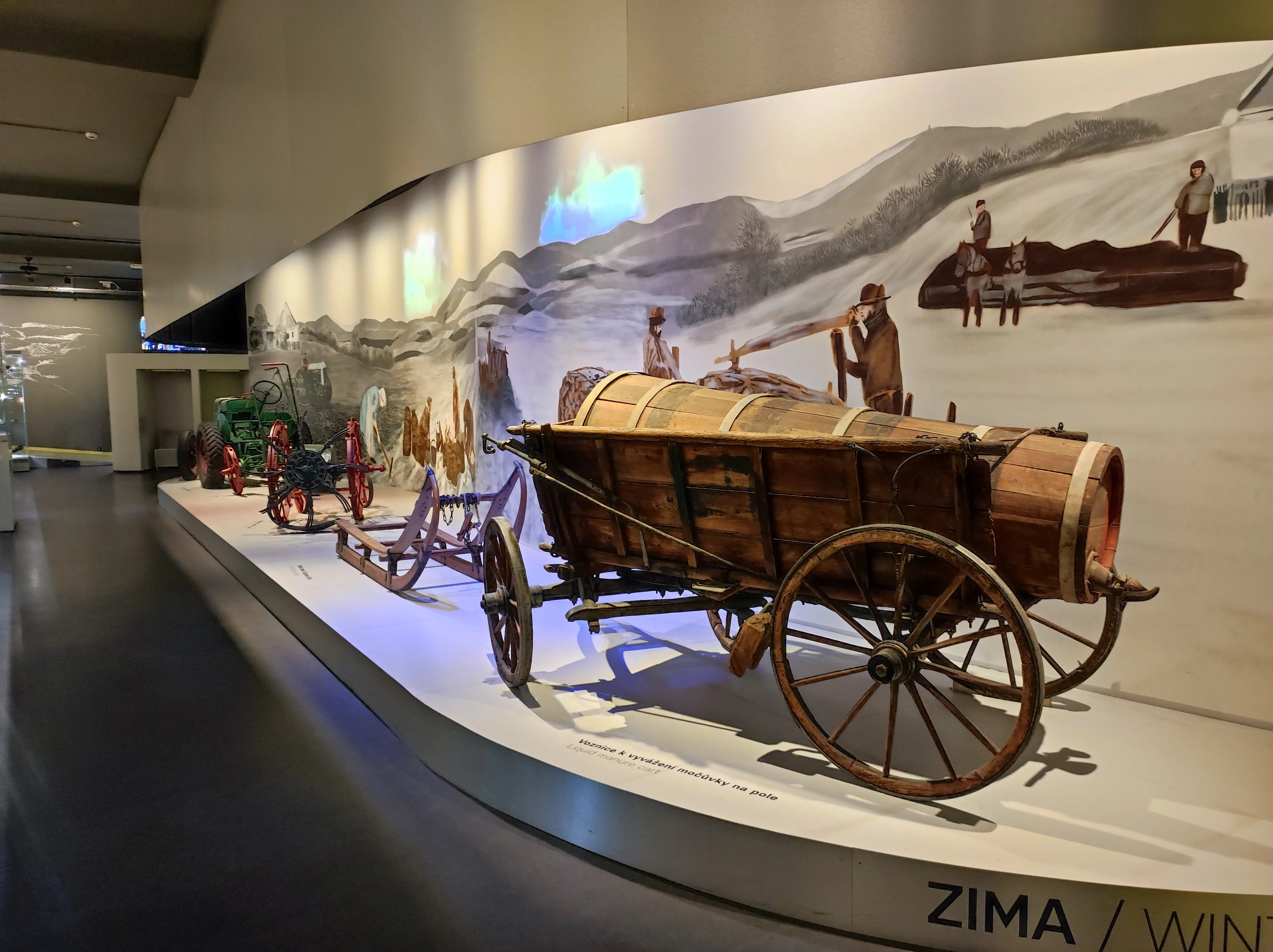 Vintage houten kar met vaten te zien in een museumgalerij