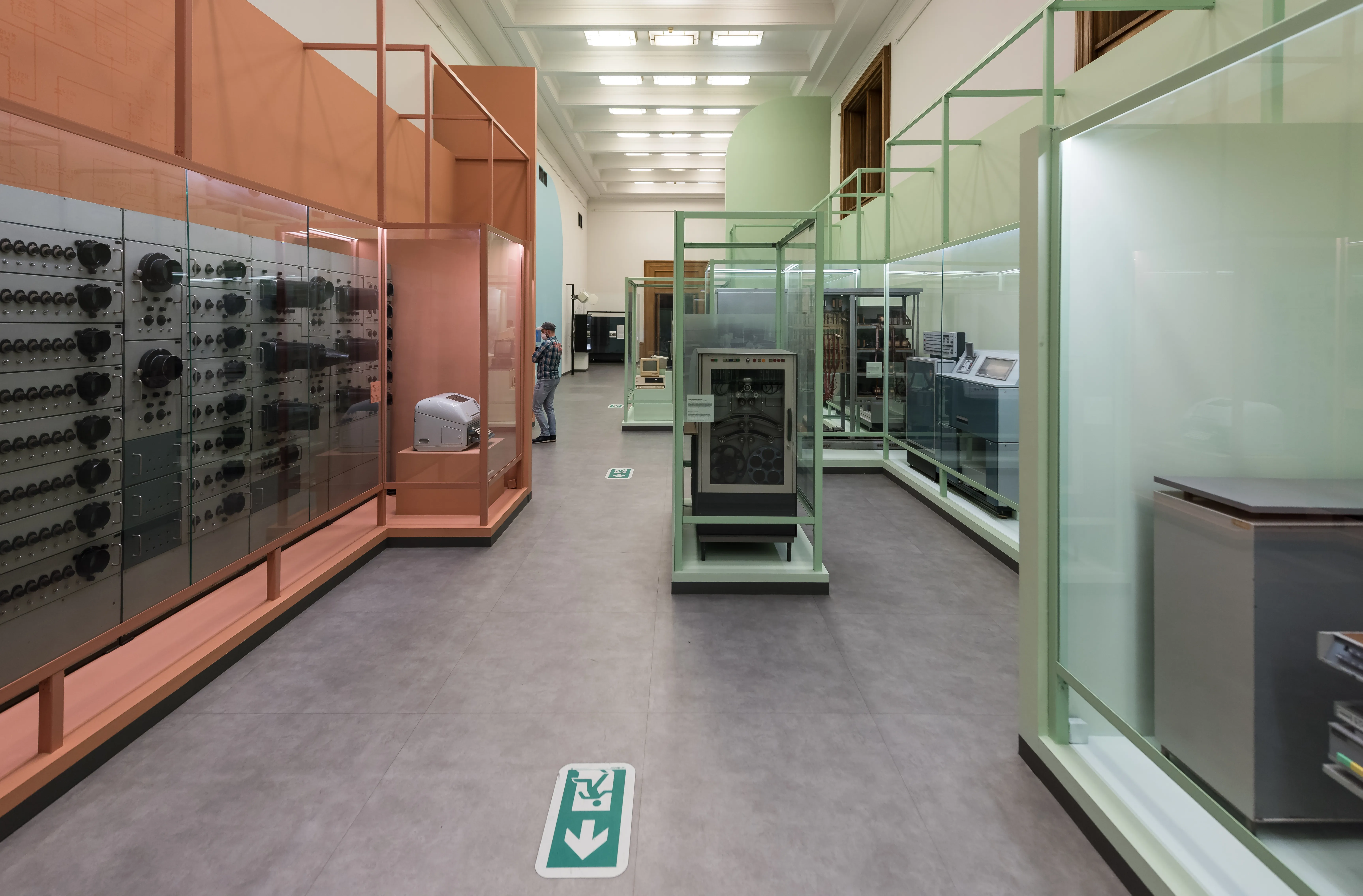 Pasillo interior de un museo con vitrinas de cristal y equipo antiguo en las paredes