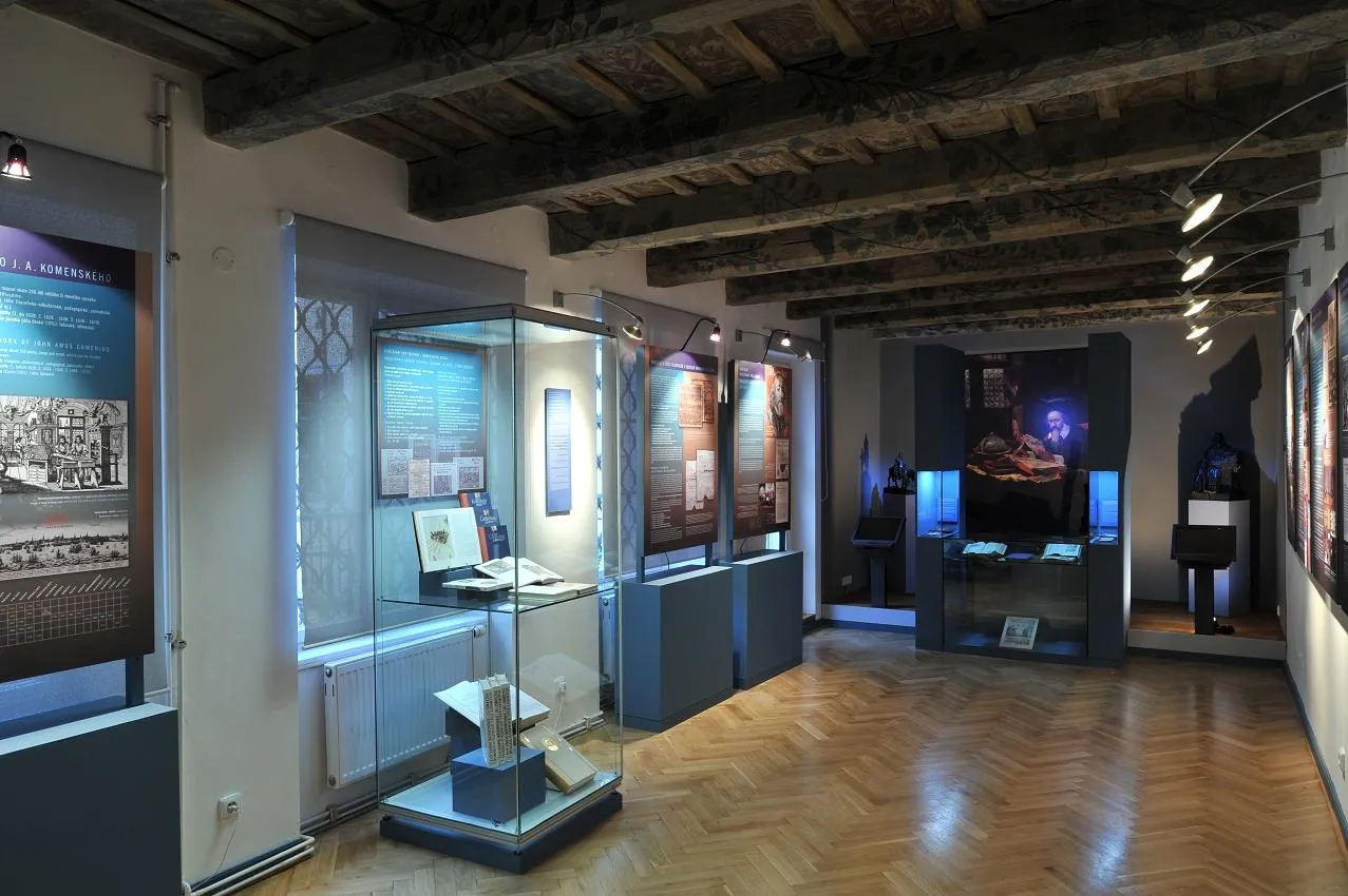 interieur van een museum met glazen vitrines, houten balken en informatiepanelen