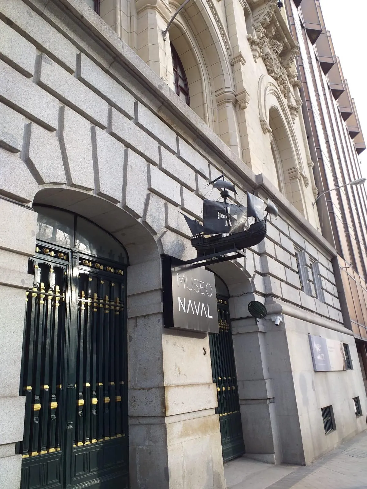 stone building entrance with arched doorway, black gate, and sign reading MUSEO NAVAL
