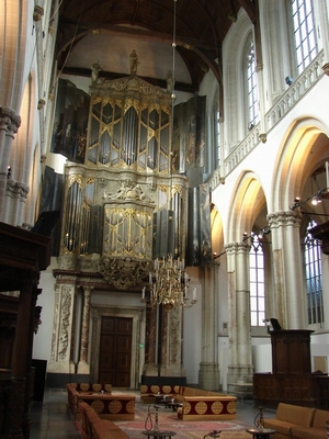 Interior of Nieuwe Kerk Amsterdam with a large ornate pipe organ and arched windows