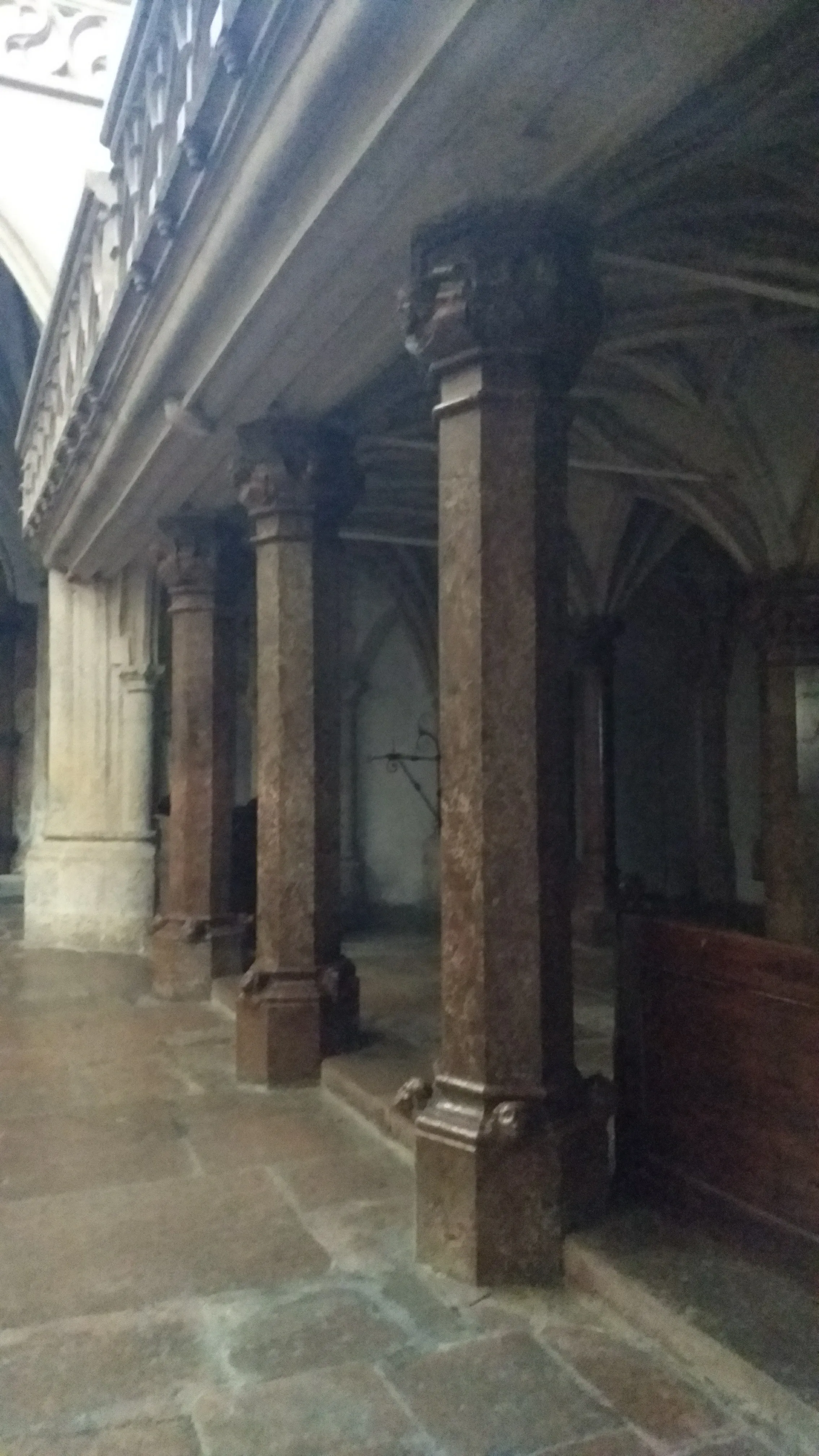 Row of stone pillars with carved capitals supporting a vaulted ceiling inside Nonnberg Abbey.