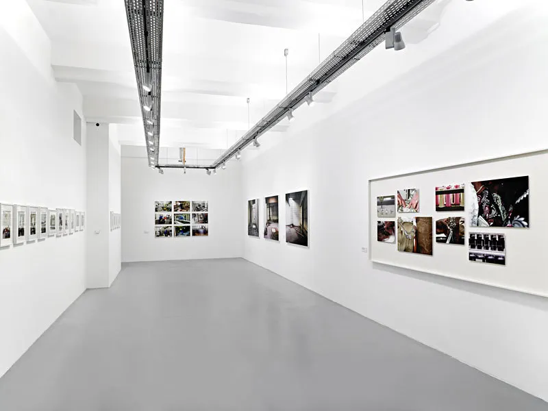 pasillo de galería blanca con fotografías enmarcadas en las paredes e iluminación industrial