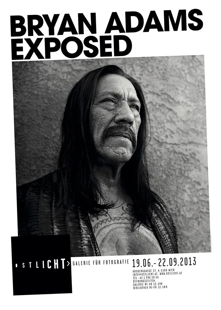 Retrato en blanco y negro de un hombre con pelo largo y bigote, con el texto 'BRYAN ADAMS EXPOSED' y 'OSTLICHT GALERIE FÜR FOTOGRAFIE' en un póster.