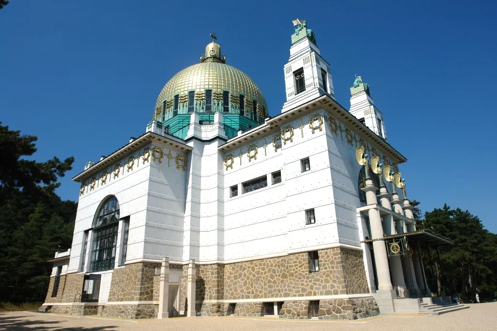 Kościół am Steinhof ze złotą kopułą i białym frontonem pod błękitnym niebem