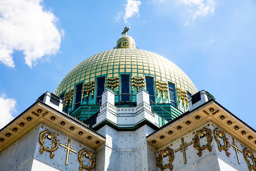 Zbliżenie złotych kopuł i ozdobnej fasady Kościoła Otto Wagnera w Steinhof na tle błękitnego nieba