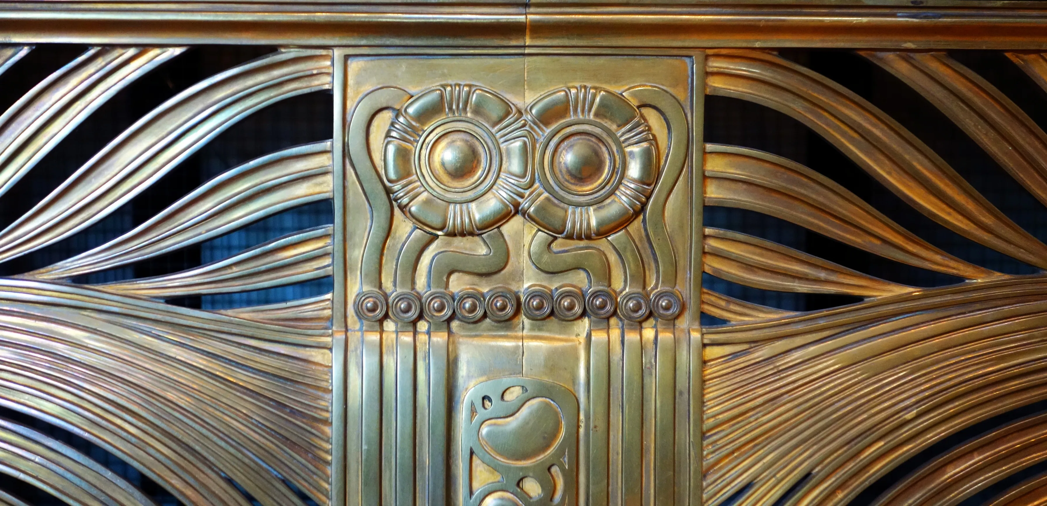 versierd metalen paneel met bloemmotieven en vloeiende lijnen