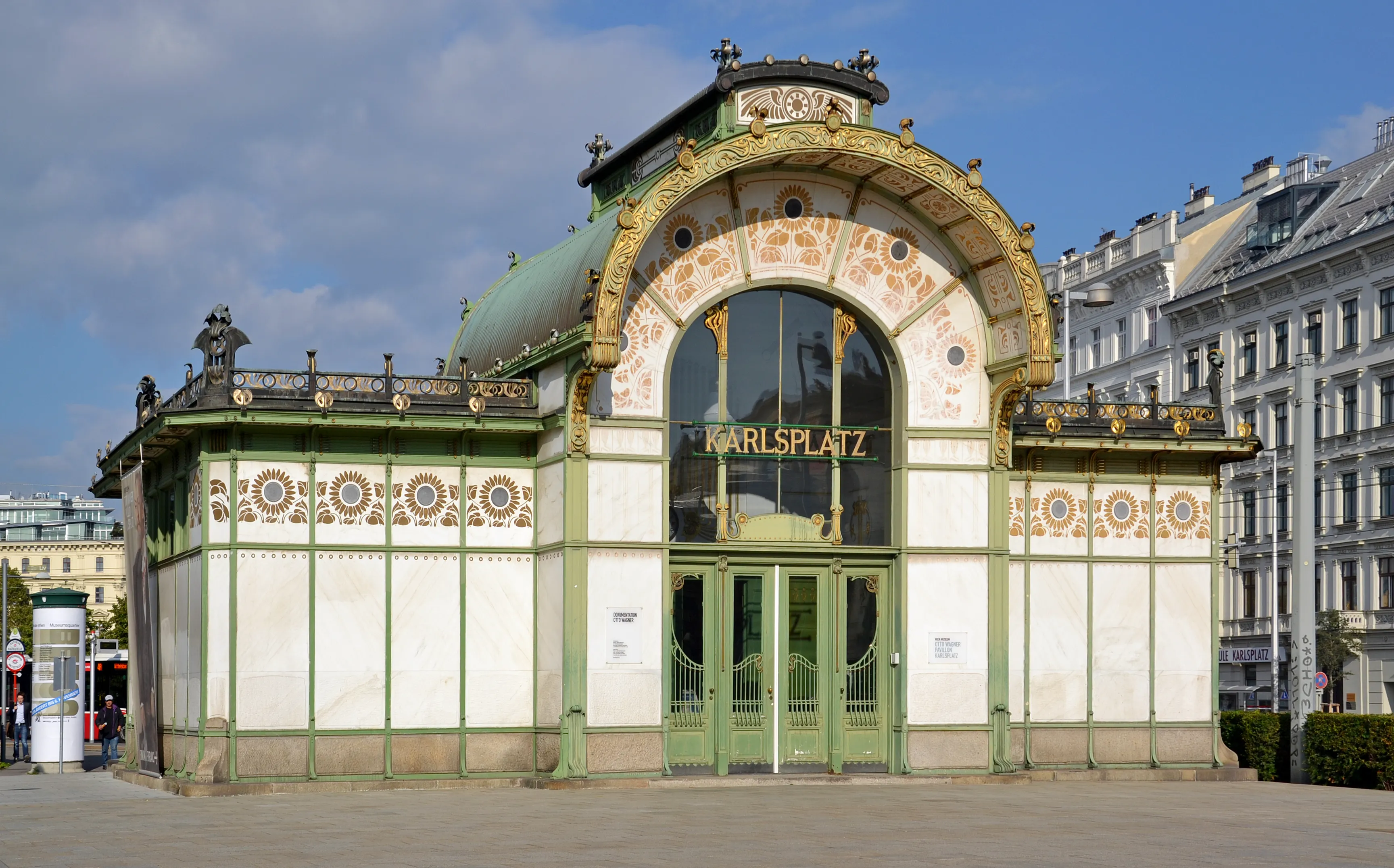Pabellón de Art Nouveau con fachada verde y blanca, patrones ornamentales de azulejos y entrada arqueada que muestra el texto 'KARLSPLATZ'