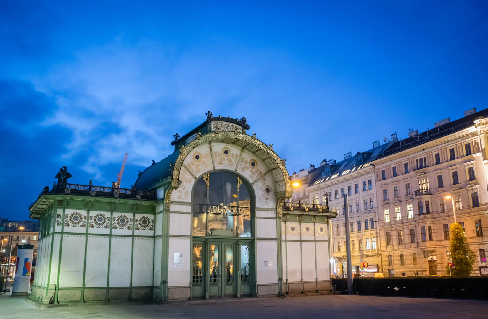 Art nouveau pavilion with arched glass entrance and decorative facade at dusk