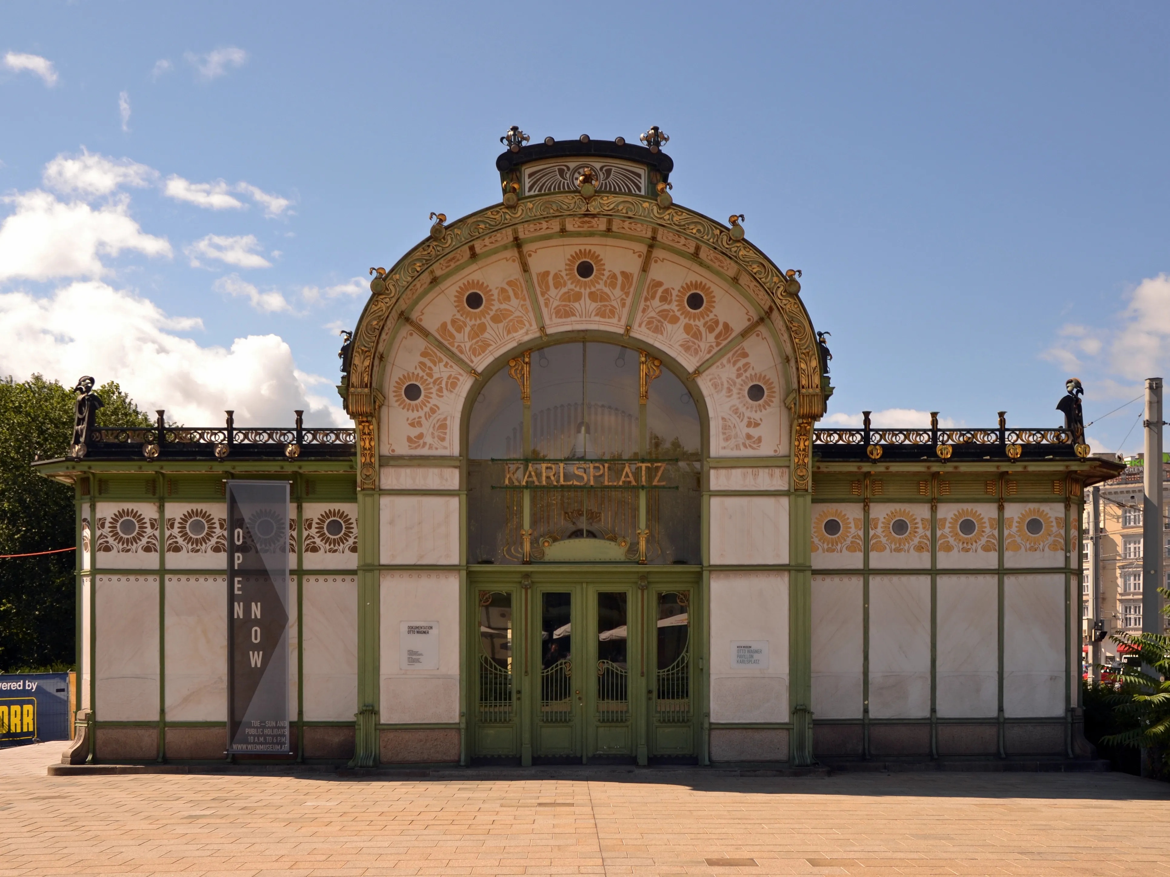 Pabellón Art Nouveau con entrada arqueada y azulejos decorativos bajo un cielo azul