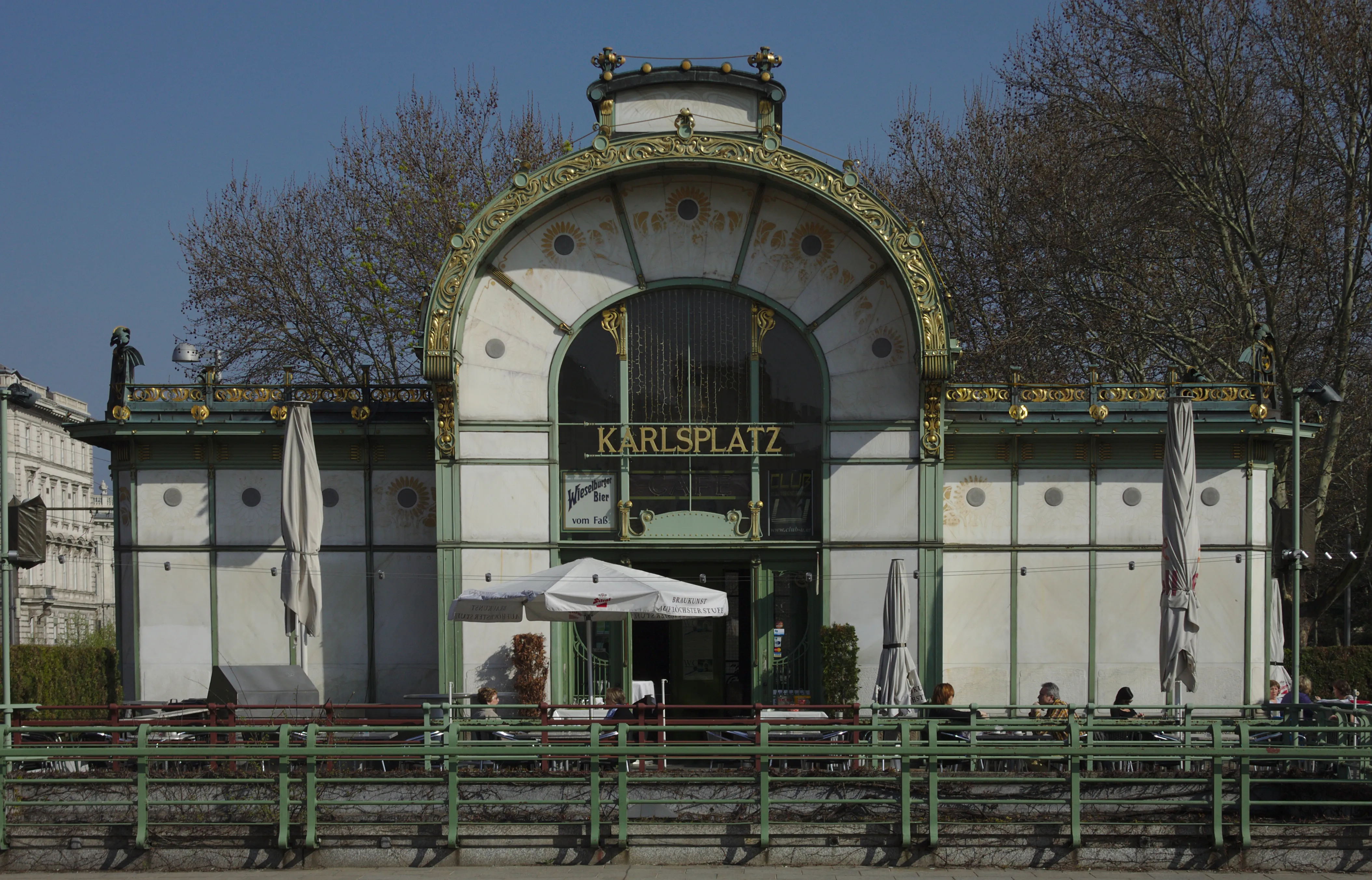 Pabellón de Art Nouveau con fachada verde y blanca y entrada arqueada que muestra el letrero 'KARLSPLATZ'