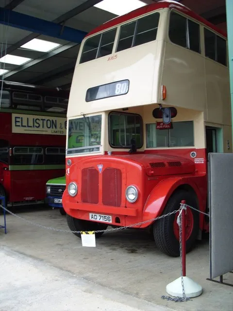 Autobús de dos pisos vintage de color rojo y crema expuesto en un museo, matrícula AD 7156, número de ruta 80