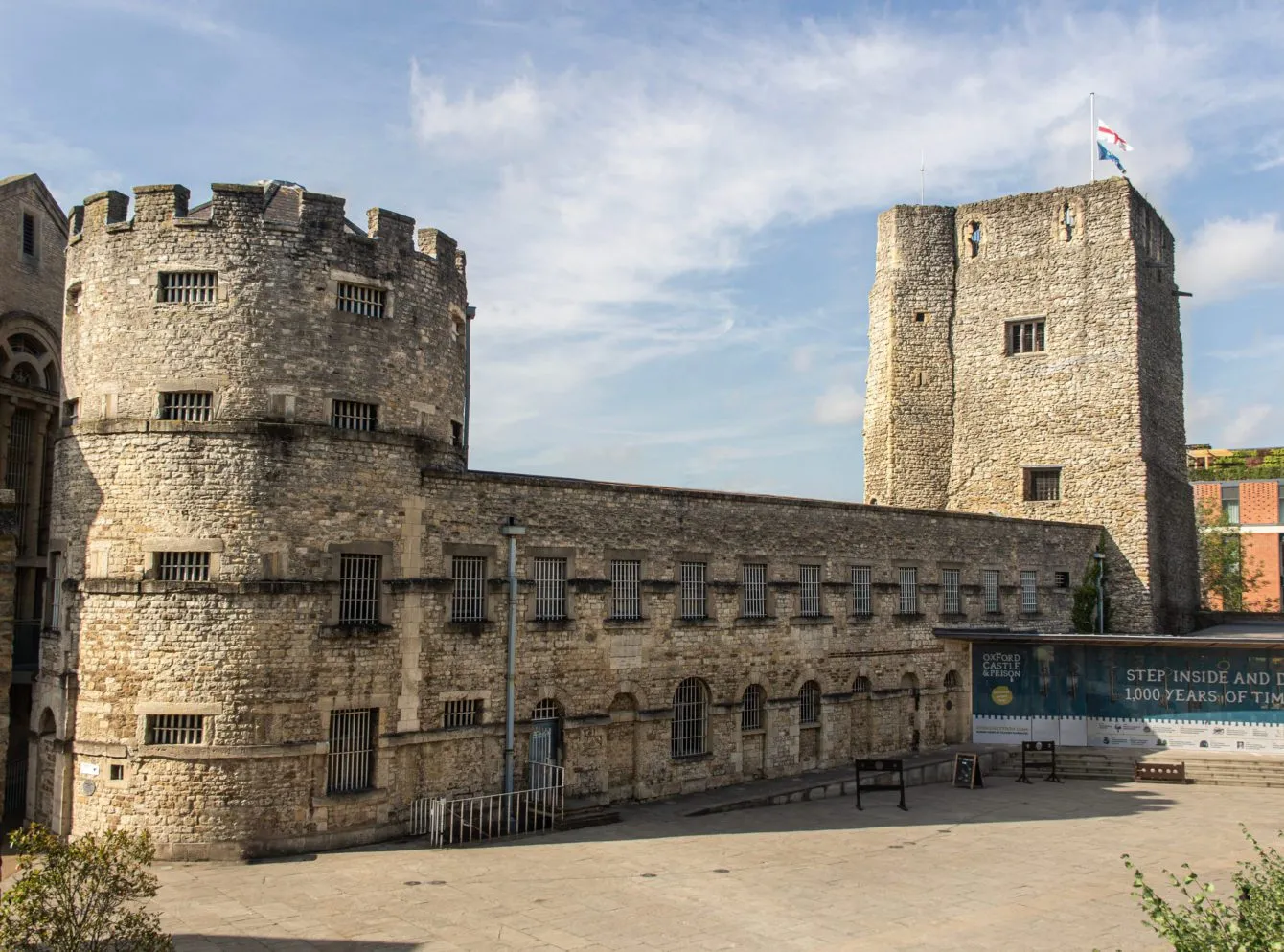 Torres de piedra y muros fortificados del Oxford Castle & Prison con una torre normanda redonda a la izquierda y una torre del homenaje cuadrada a la derecha, vistos desde el patio