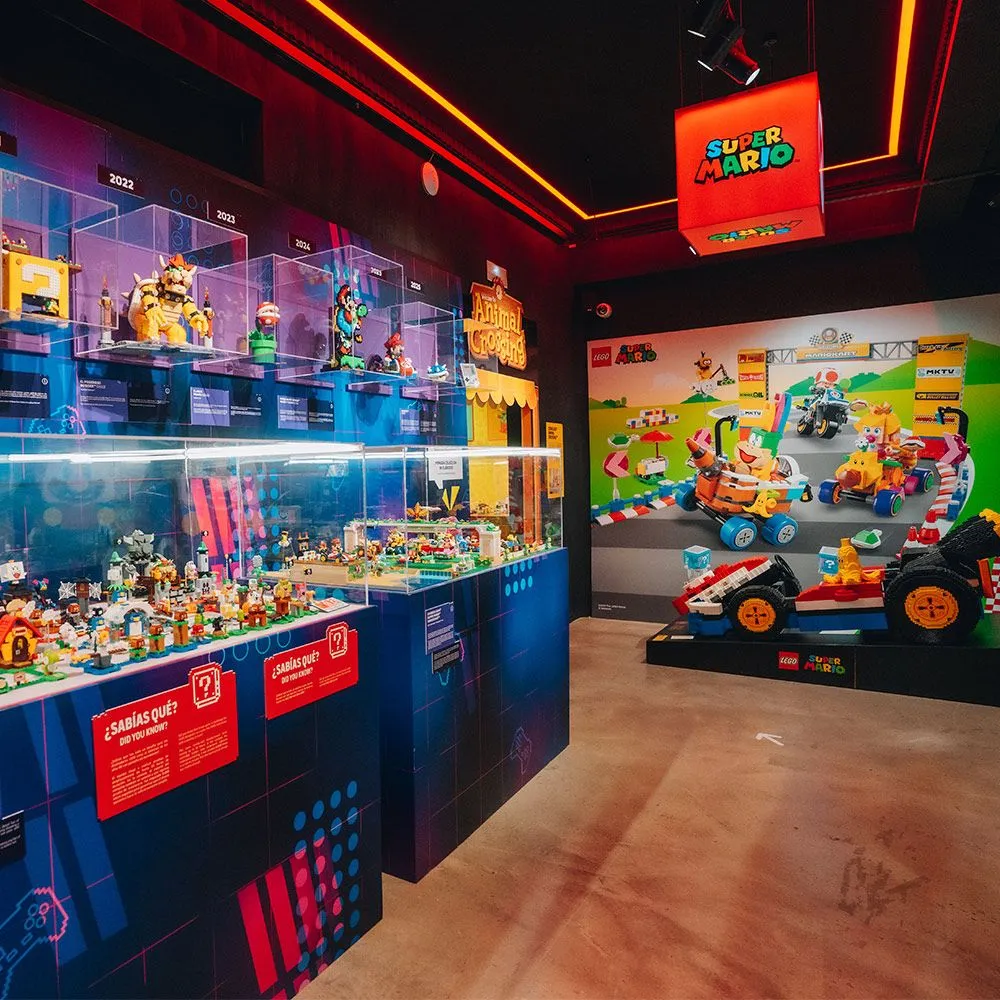 Interior of a video game museum with LEGO displays, including a Super Mario sign and a LEGO race car exhibit