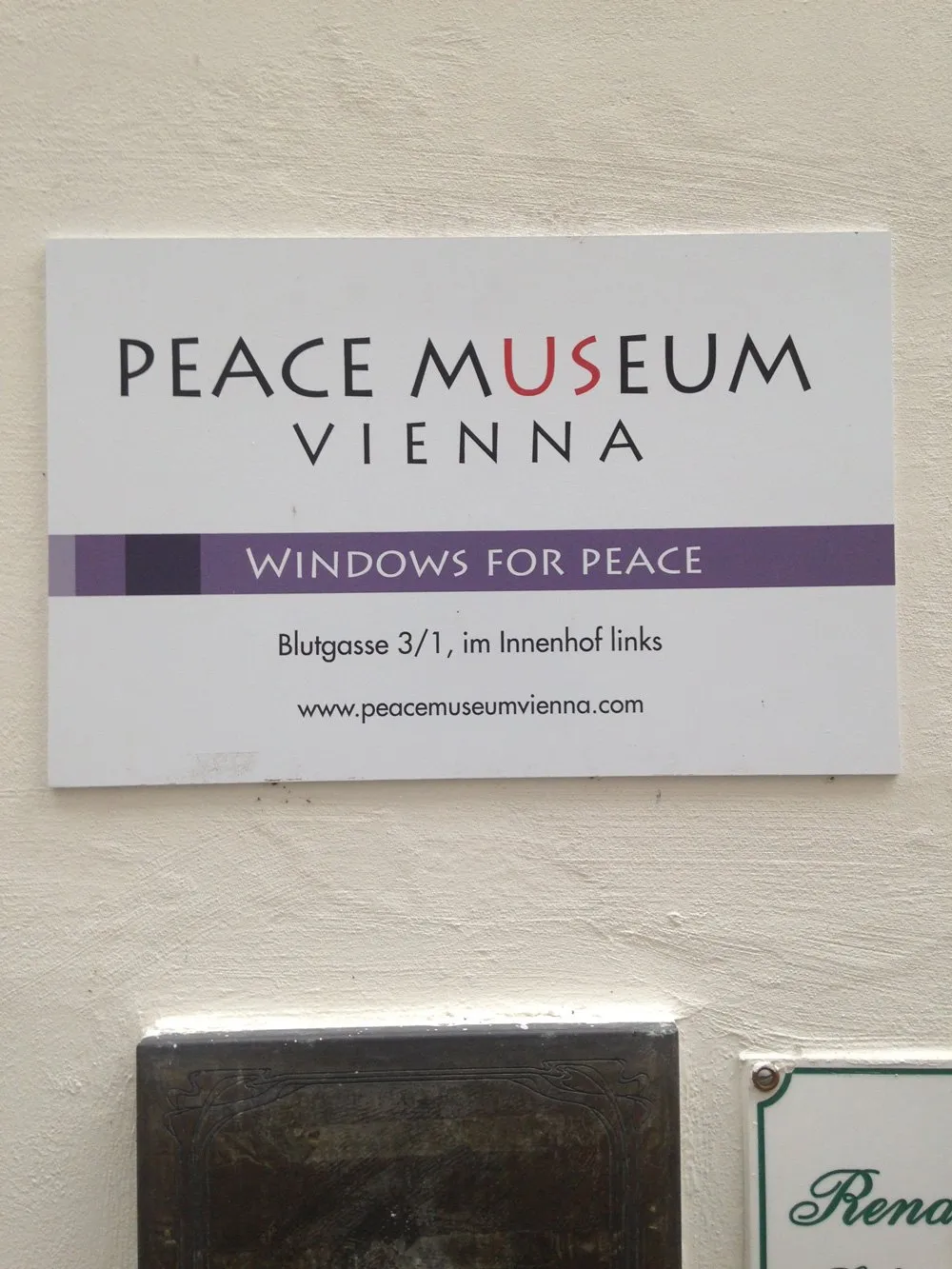 Muzeum Pokoju w Wiedniu ze sloganem 'Okna dla Pokoju' i adresem na białej tablicy