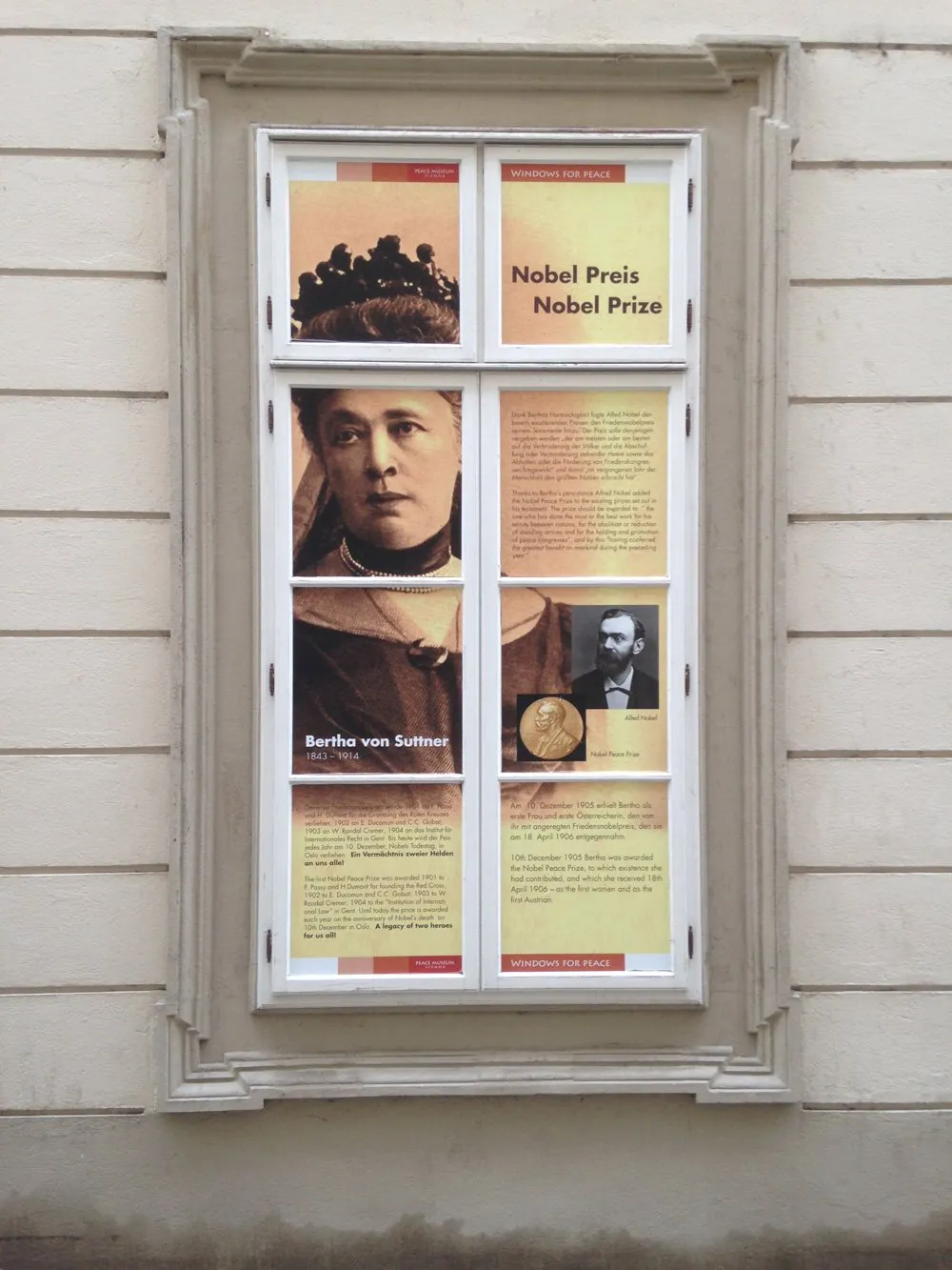 Vitrine met posters over de Nobelprijs en Bertha von Suttner op een gebouwgevel