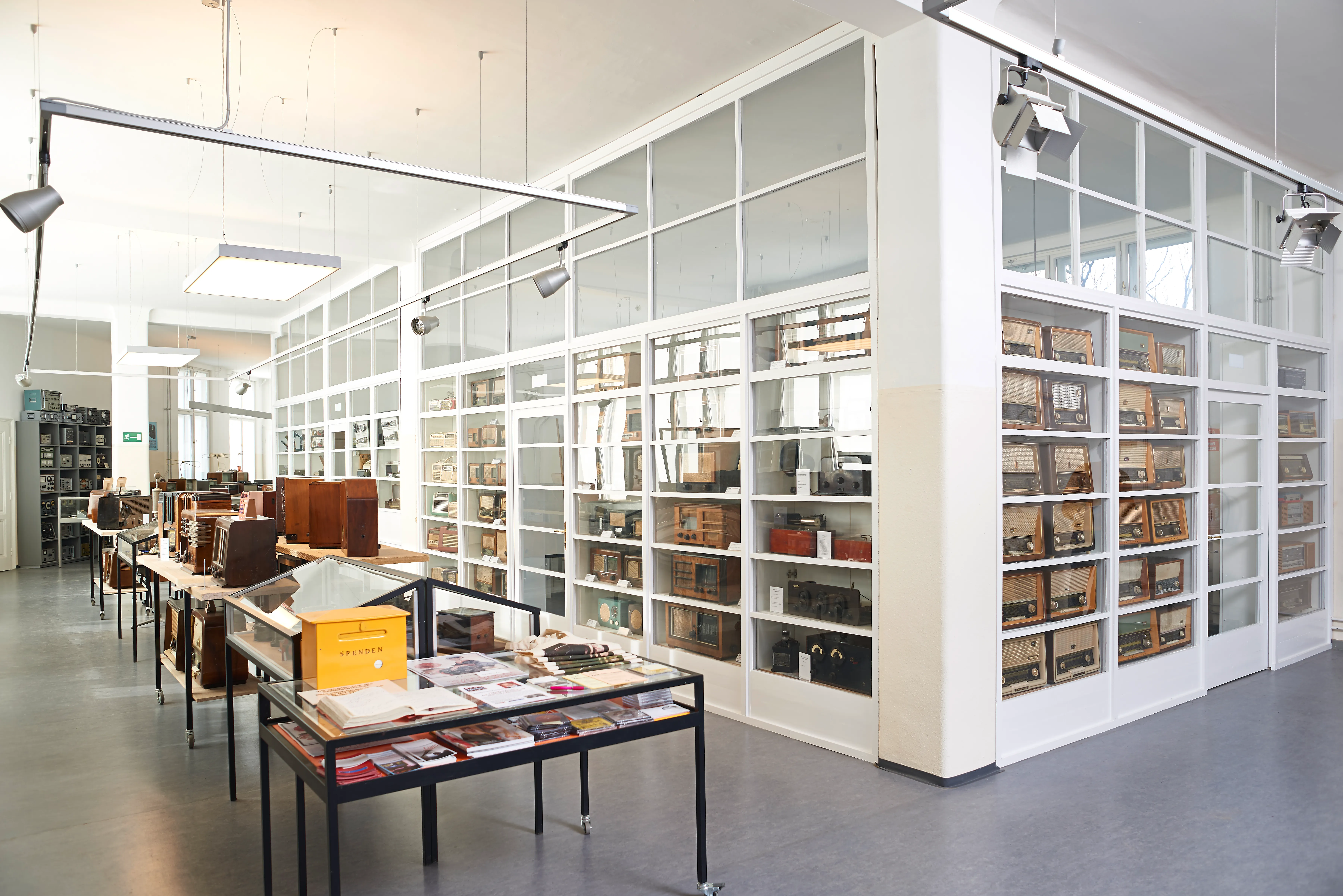 Interior of Phonomuseum Vienna with glass-fronted display cabinets and a table with books and magazines