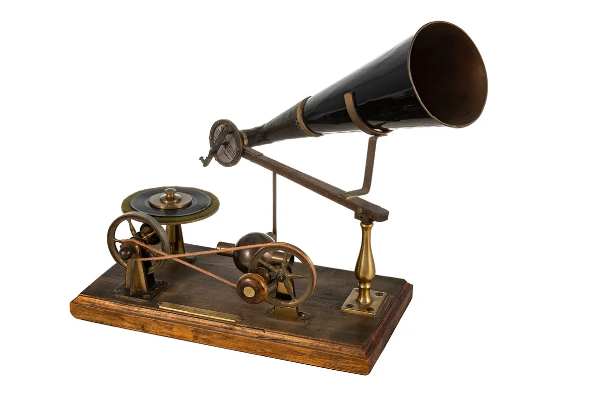 An antique gramophone with a large black horn, brass components, and a wooden base