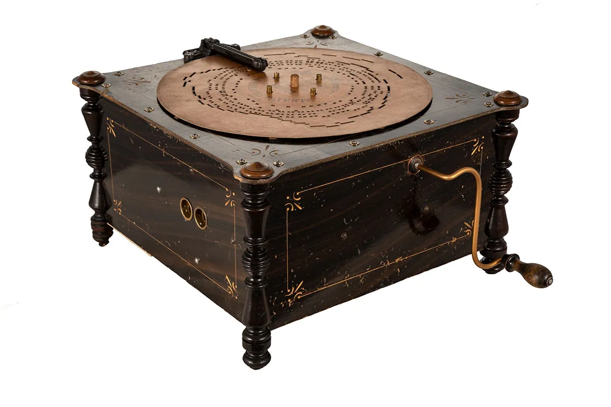 antique mechanical music box with wooden casing and brass details