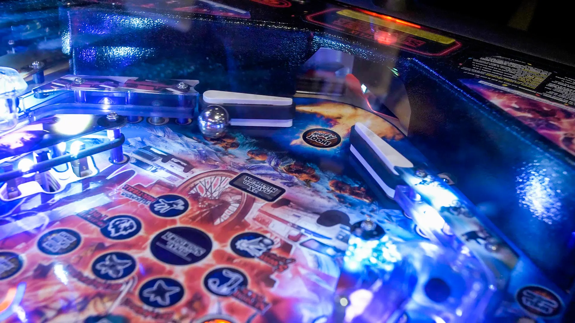 close-up of a pinball machine playfield with illuminated bumpers and colorful artwork