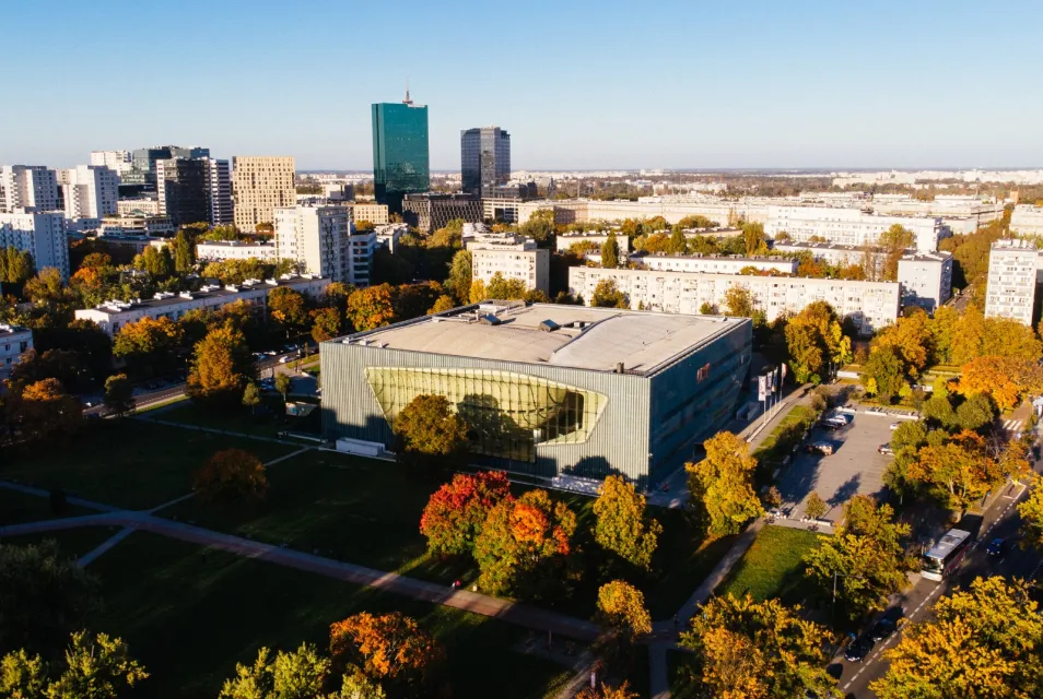 Luchtfoto van het POLIN Museum van de Geschiedenis van Poolse Joden met moderne architectuur, omgeven door herfstbomen en stadgebouwen
