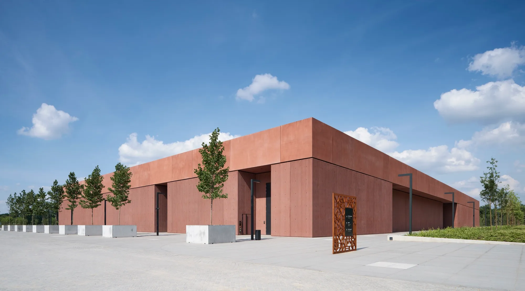 modern gebouw met roodbruine gevel onder blauwe lucht