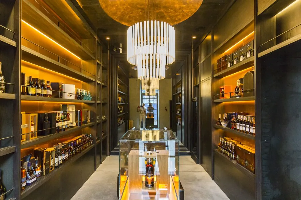 Pasillo interior de un museo con estantes de botellas de vodka y una vitrina central